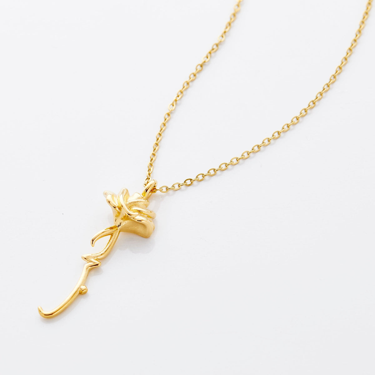An 18k gold plated necklace with the rose flower shaped pendant that features  Arabic word for ‘love’, curving in calligraphy out of the stem of the flower.