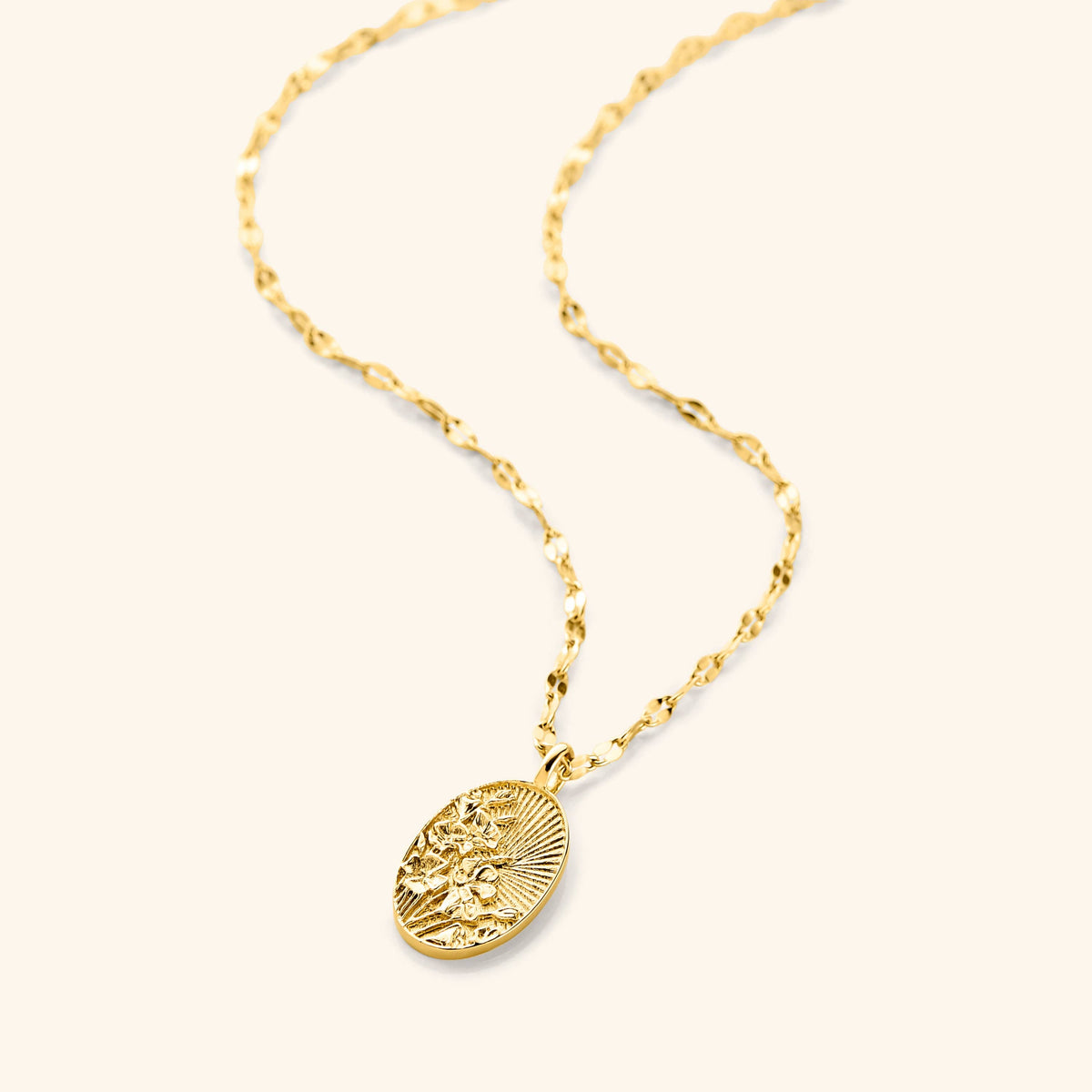An 18k gold plated necklace that  features a molded bouquet of poppies, the national flower of Palestine, on a disc that features sun rays with a vintage finish pendant hanging on a gold plated flutter chain.