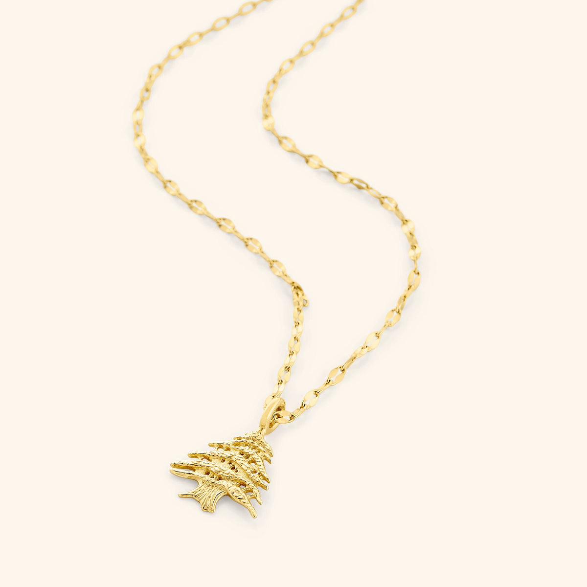 Flat lay of an 18k gold plated necklace that features the Cedar of Lebanon pendant.