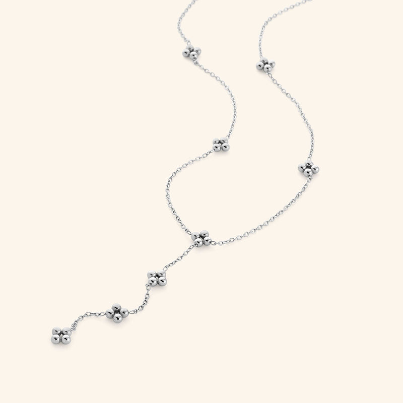Close-up of the Henna Lariat Necklace in silver pimage_ featuring delicate chain links with small clustered bead accents and a drop lariat design.