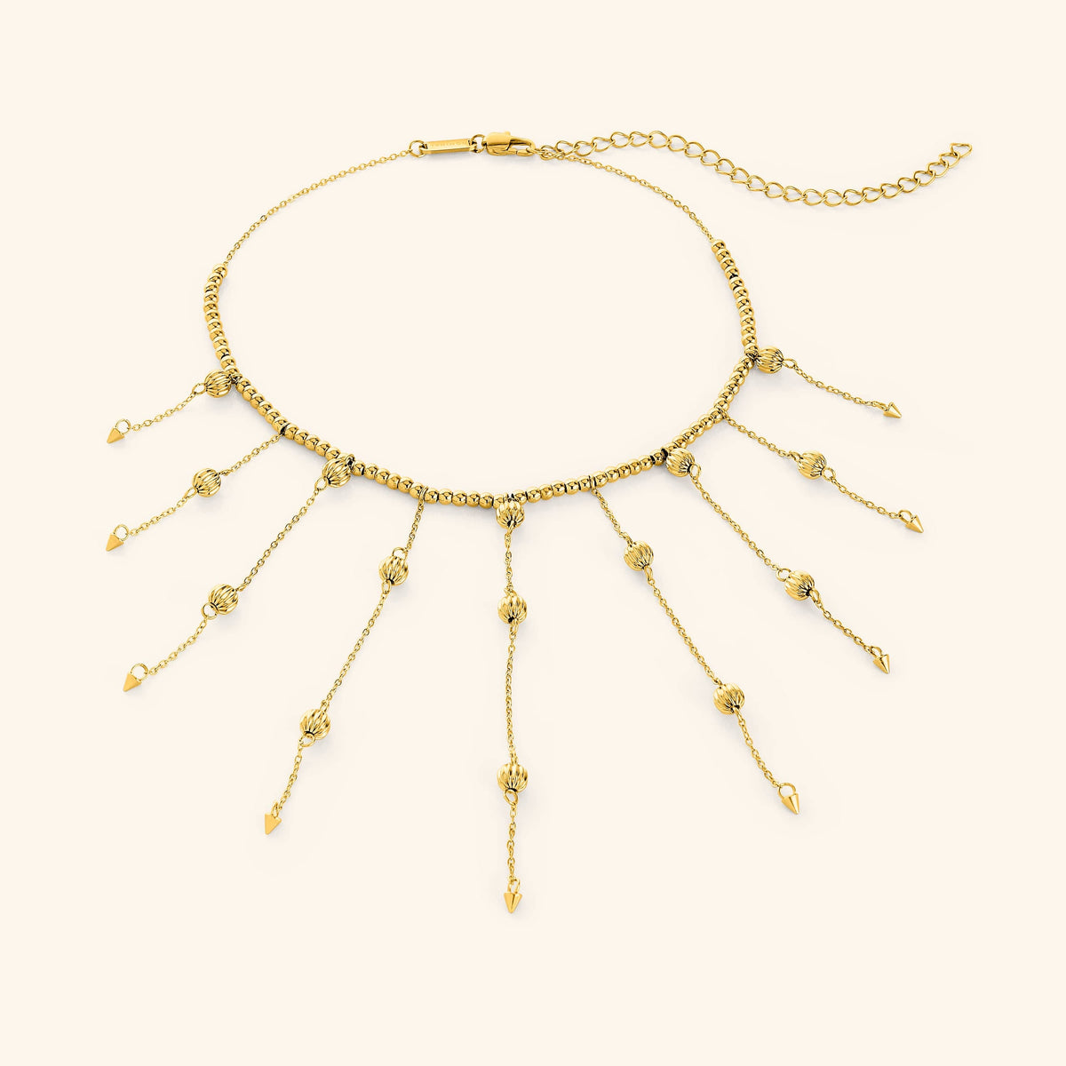 Flat lay of an 18k gold plated necklace that  features a dotted chain all along the necklace and drops each lariat 3.5 inches down with delicate, evenly spaced orbs