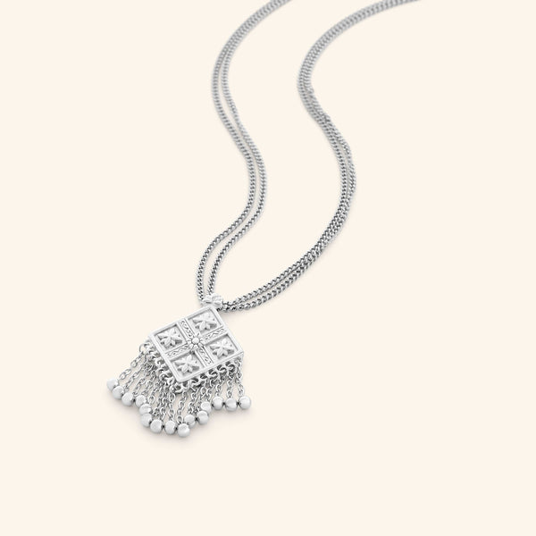 silver dancing kite necklace with a diamond pendant featuring floral engravings and dangling chains with small silver beads.