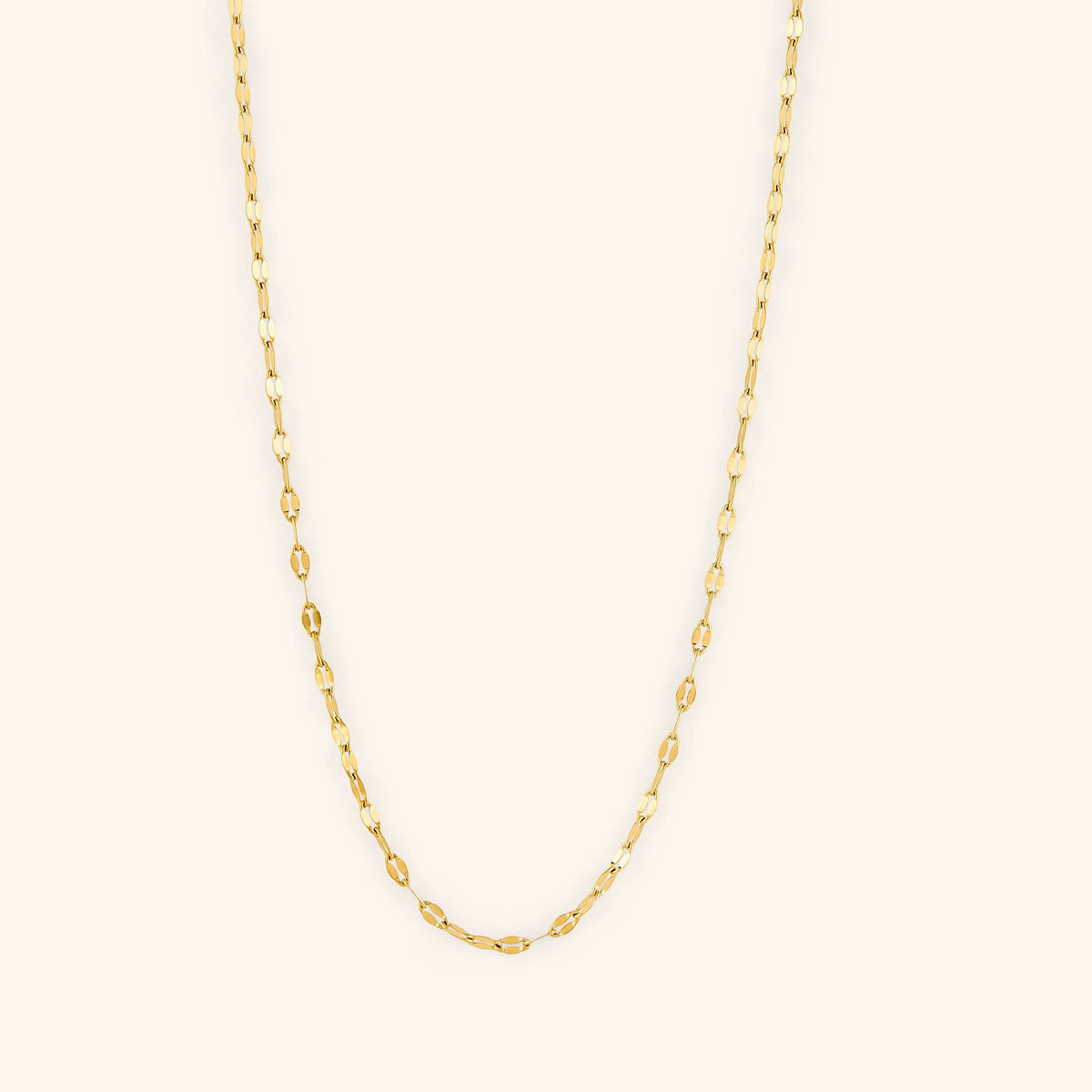 Photo of a minimalistic 18k gold plated necklace against a light background.