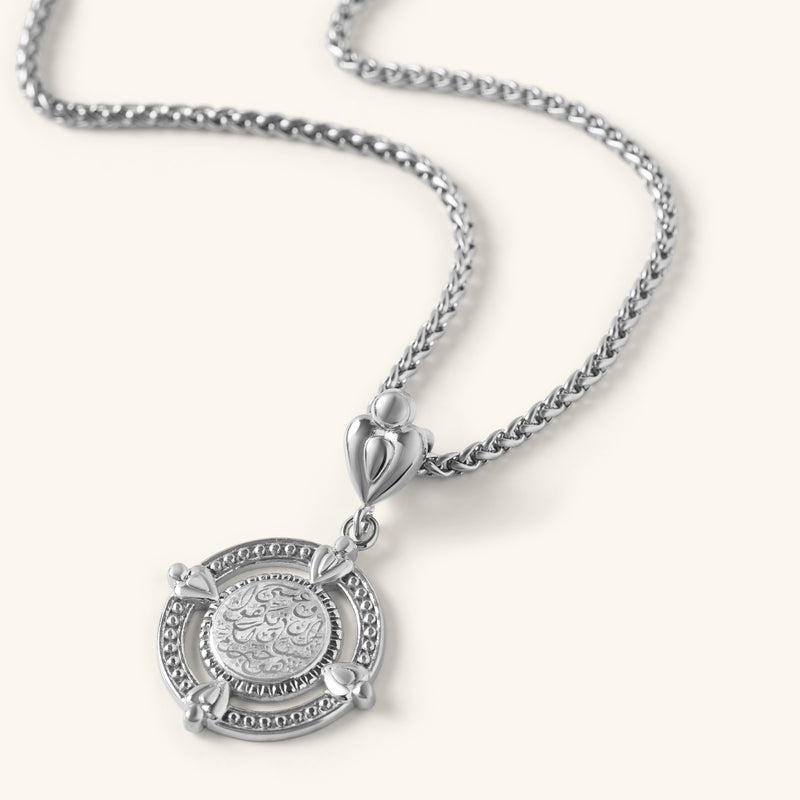 “Perhaps you dislike what's good for you” Coin Necklace in silver with engraved Arabic calligraphy and a decorative round frame.