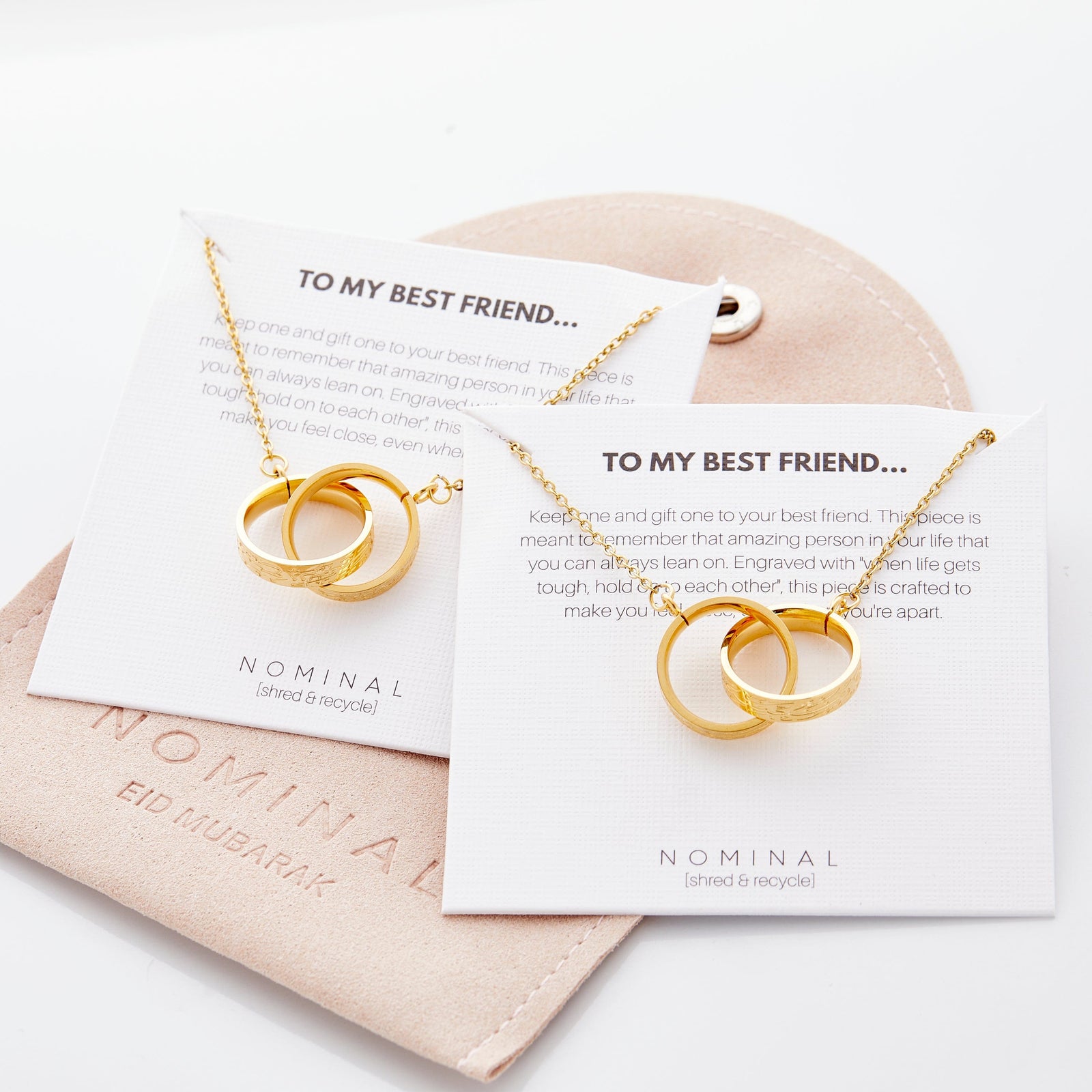 The interlocked necklace set displayed inside a beige Nominal drawstring pouch, showcasing the product’s gift-ready packaging.