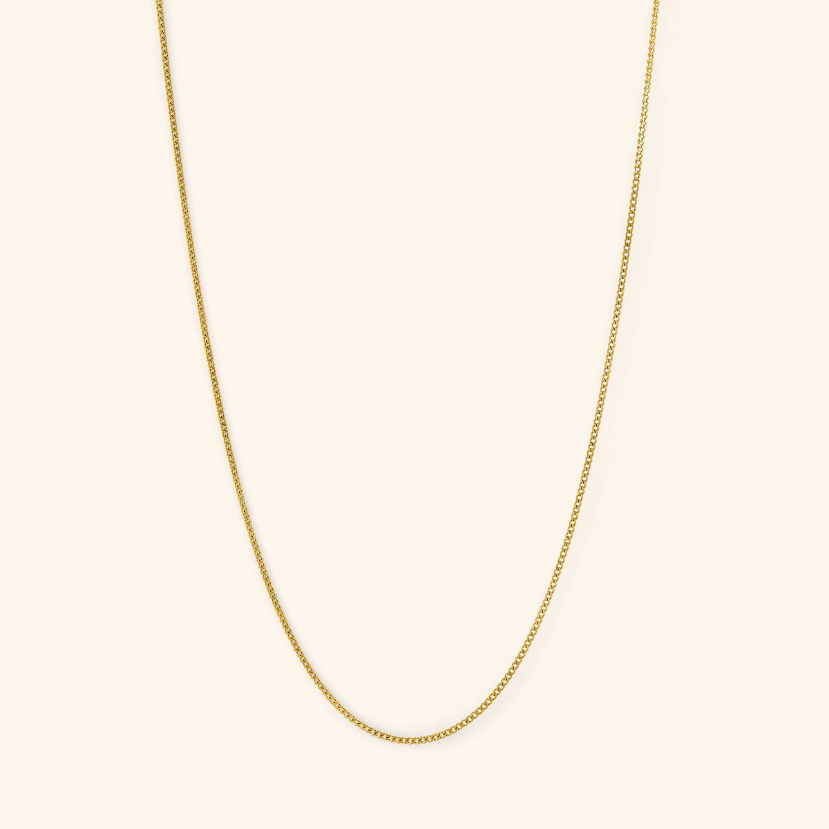 Photo of the gold Micro Curb Chain against a light background. This necklace  features a 1MM flat oval chain pattern.
