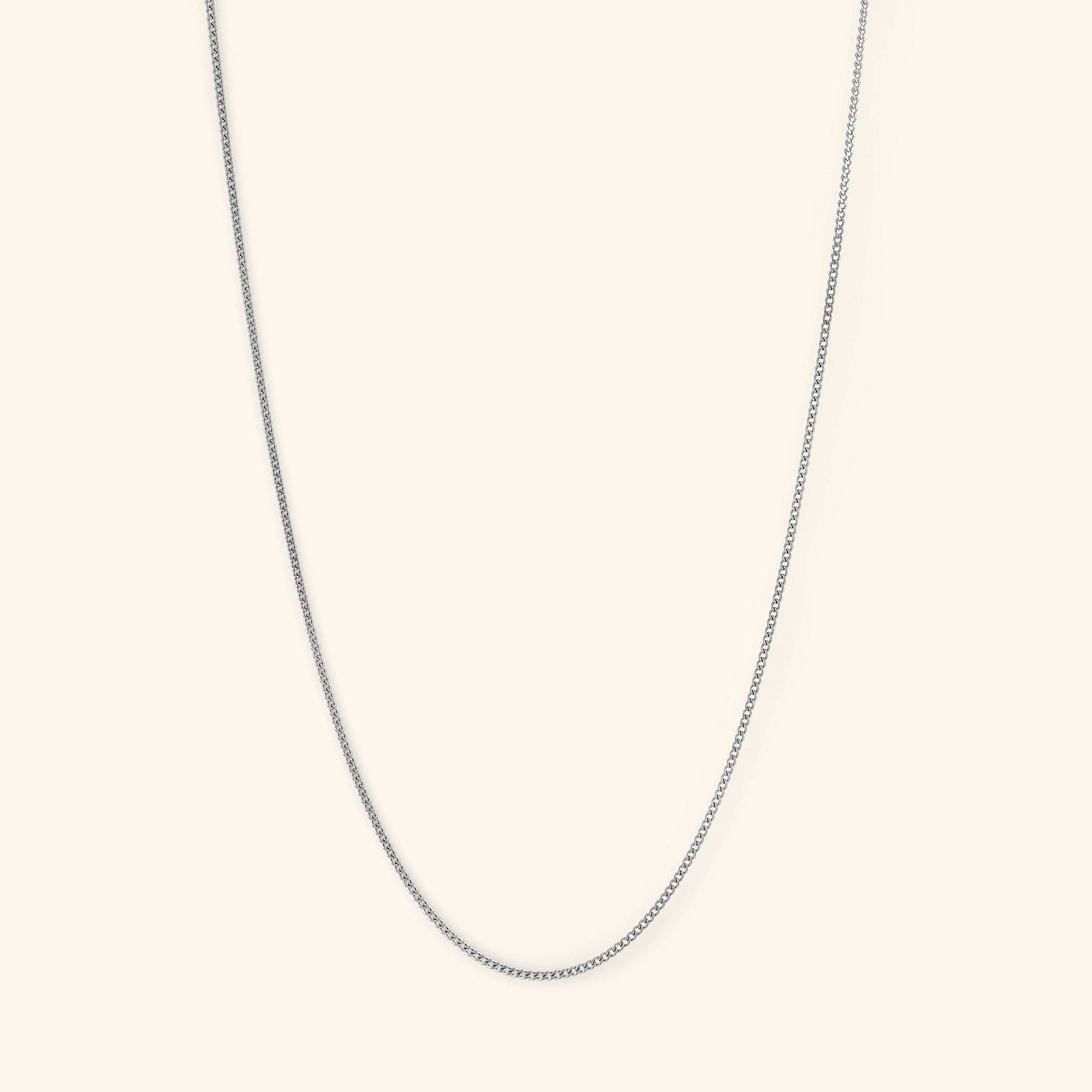 Photo of the silver Micro Curb Chain against a light background. This necklace  features a 1MM flat oval chain pattern.