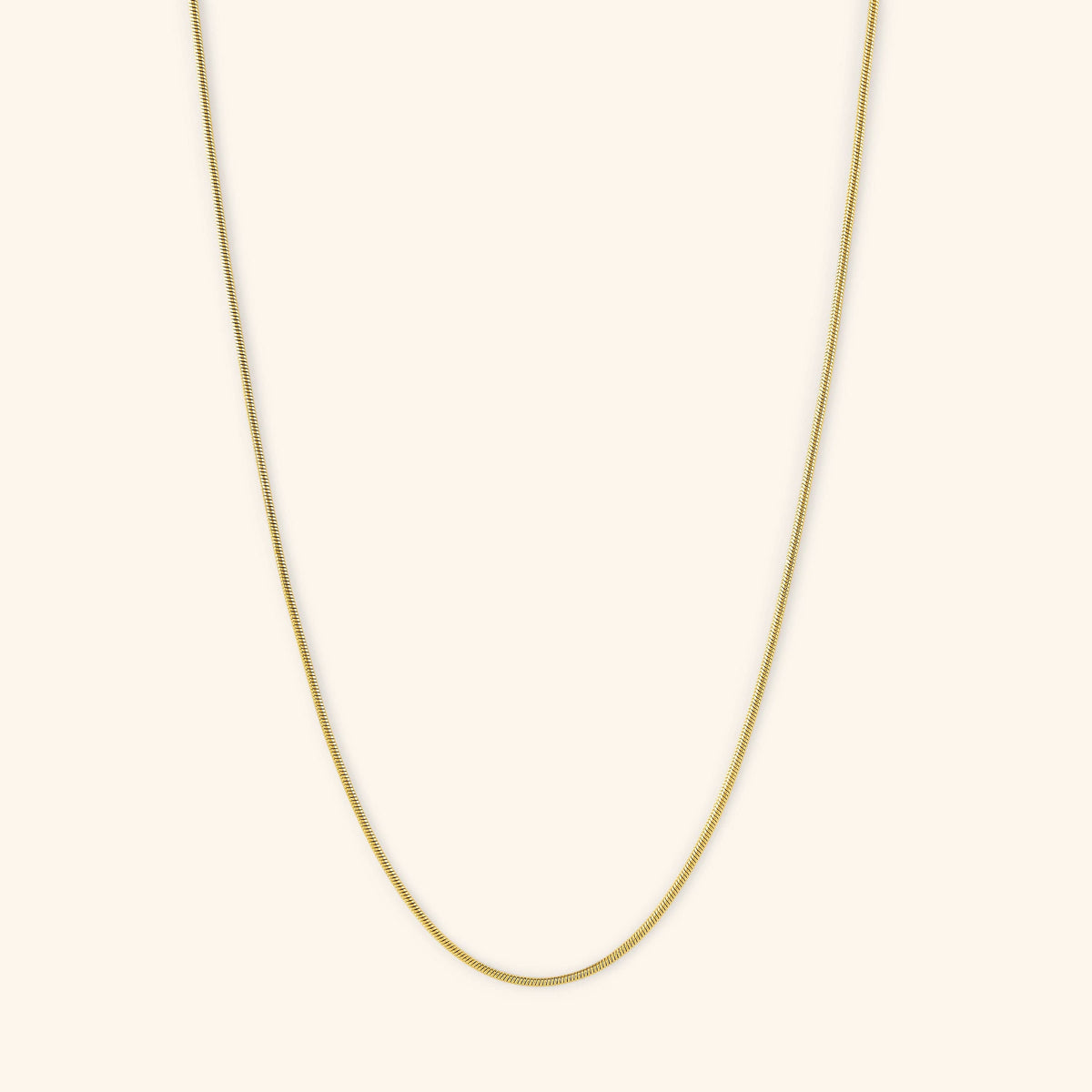 Flat lay of the 18k gold plated Micro Harmony Chain. This necklace features a 1MM seamless snake-like chain pattern