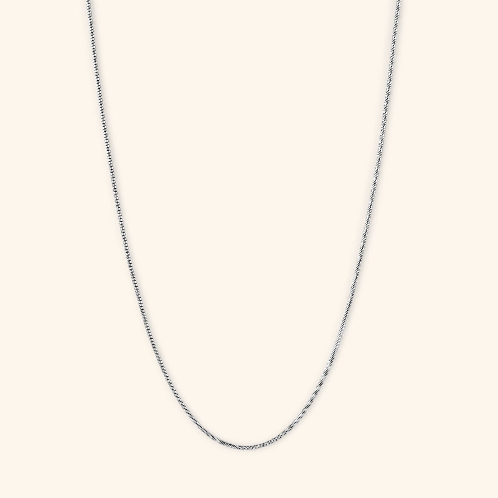 Flat lay of the silver  Micro Harmony Chain. This necklace features a 1MM seamless snake-like chain pattern
