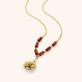 18k gold plated chain necklace with a detailed ruffled flower pendant and dark reddish-brown tube beads.