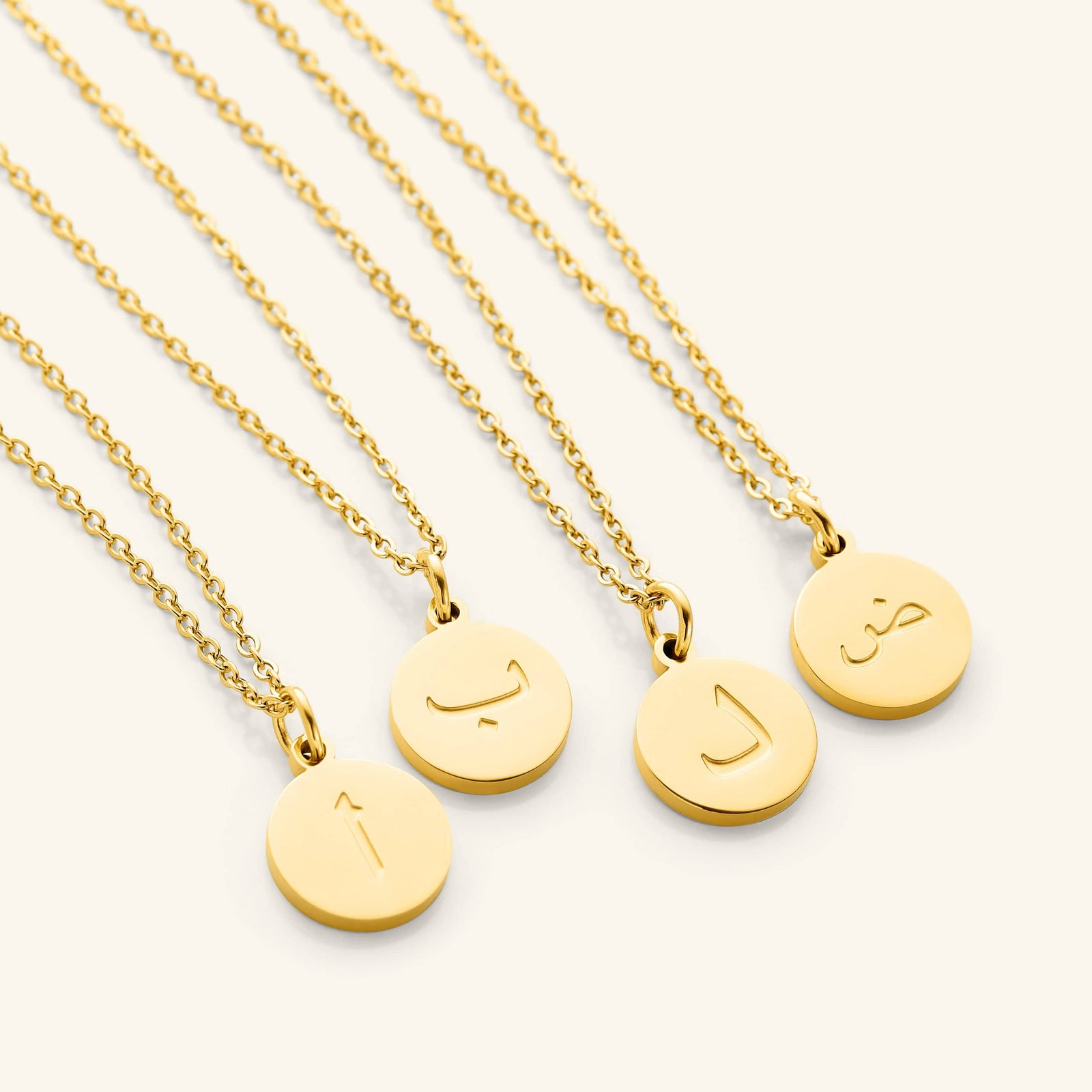 Photo of a set of Arabic Letter Necklace with different letters on each pendant.