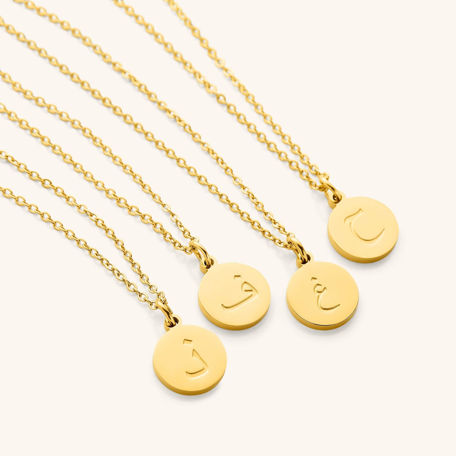 Photo of a set of Arabic Letter Necklace with different letters on each pendant.