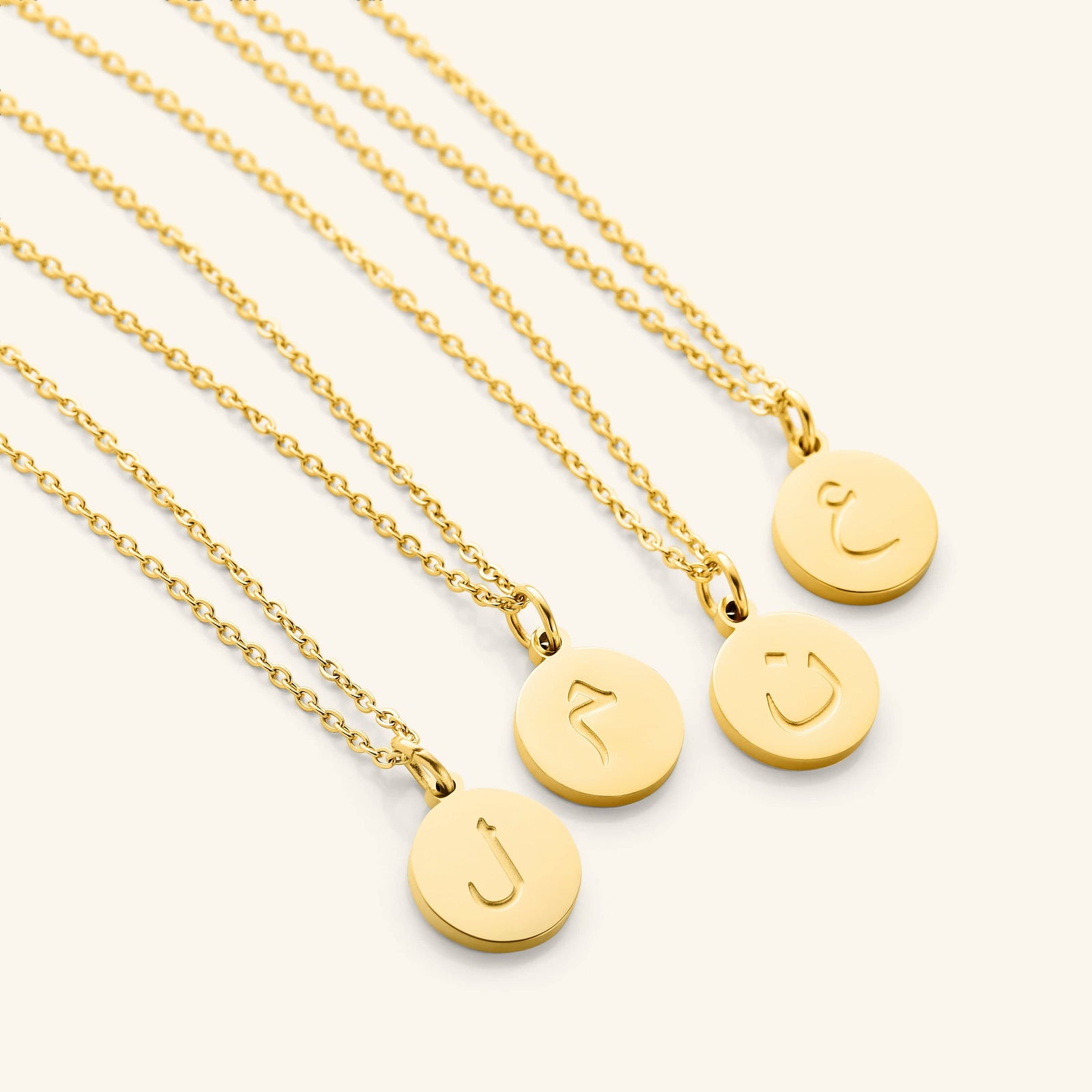 Photo of a set of Arabic Letter Necklace with different letters on each pendant.