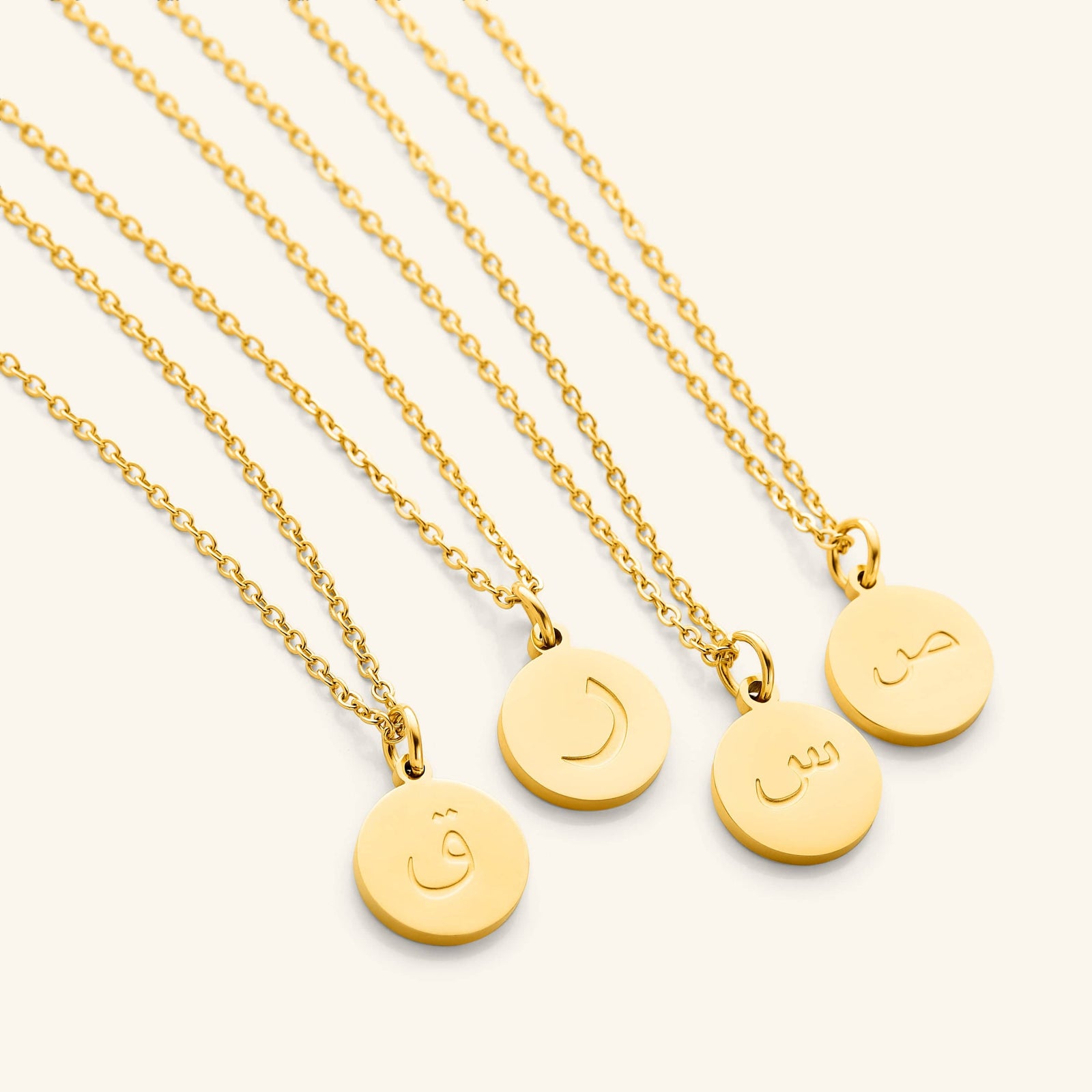 Photo of a set of Arabic Letter Necklace with different letters on each pendant.
