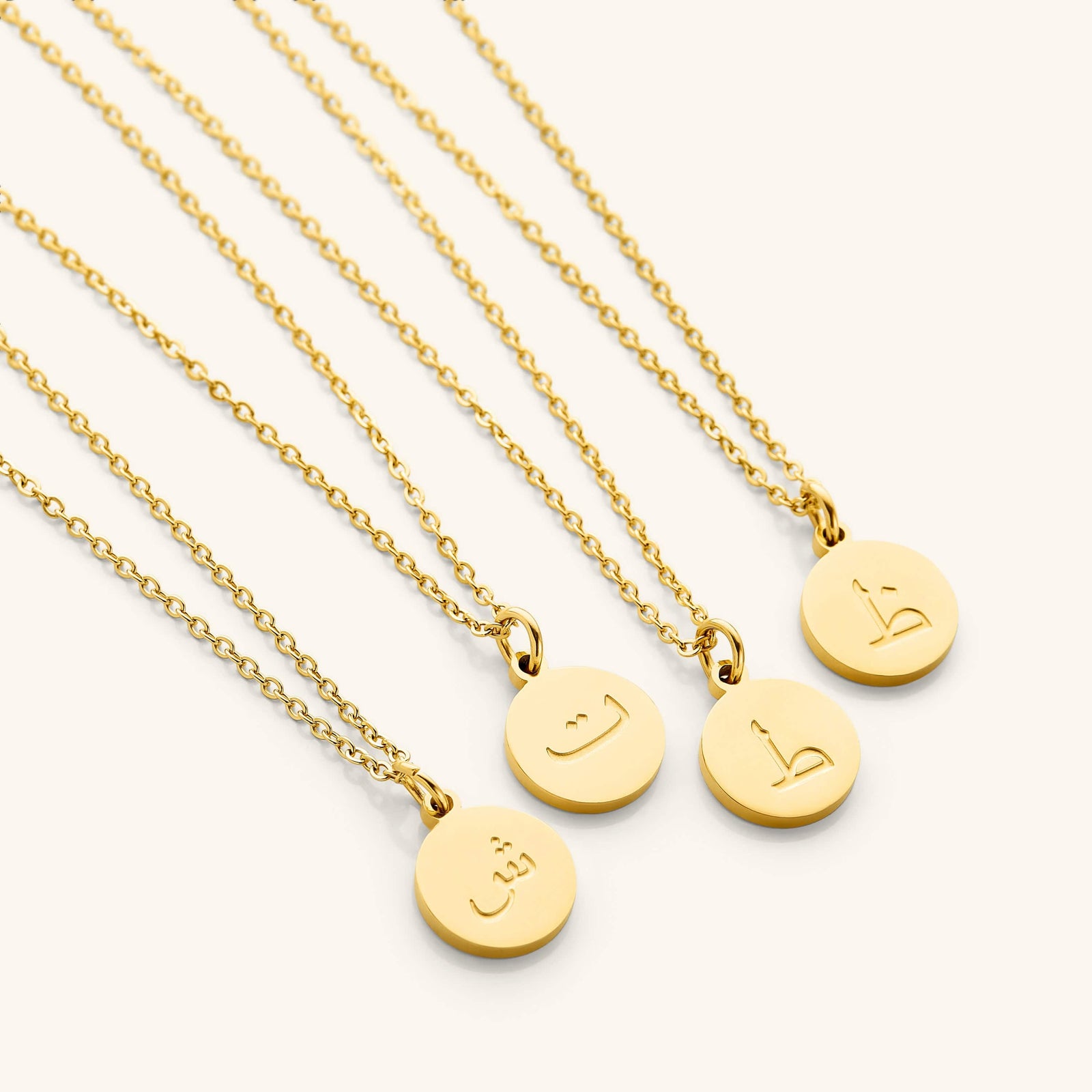 Photo of a set of Arabic Letter Necklace with different letters on each pendant.