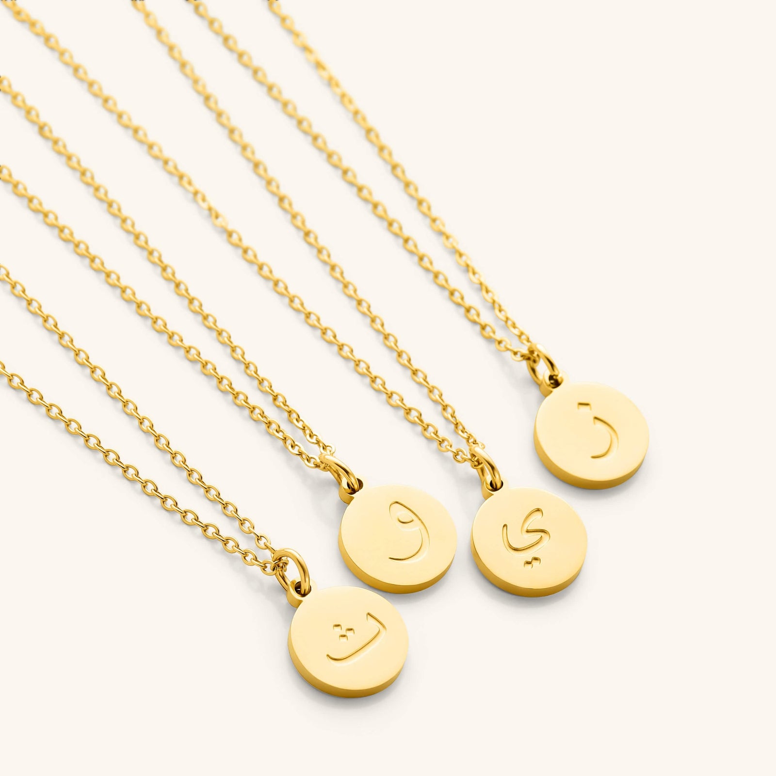 Photo of a set of Arabic Letter Necklace with different letters on each pendant.