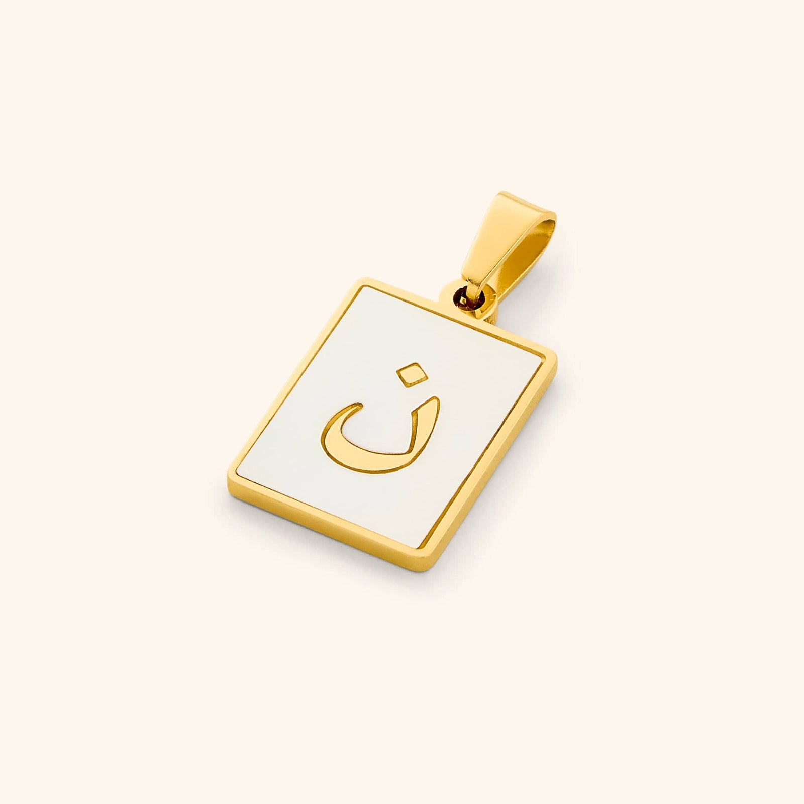 Close-up of the Arabic letter charm "ن" (Noon) in 18K gold plating, with an iridescent pearl background.