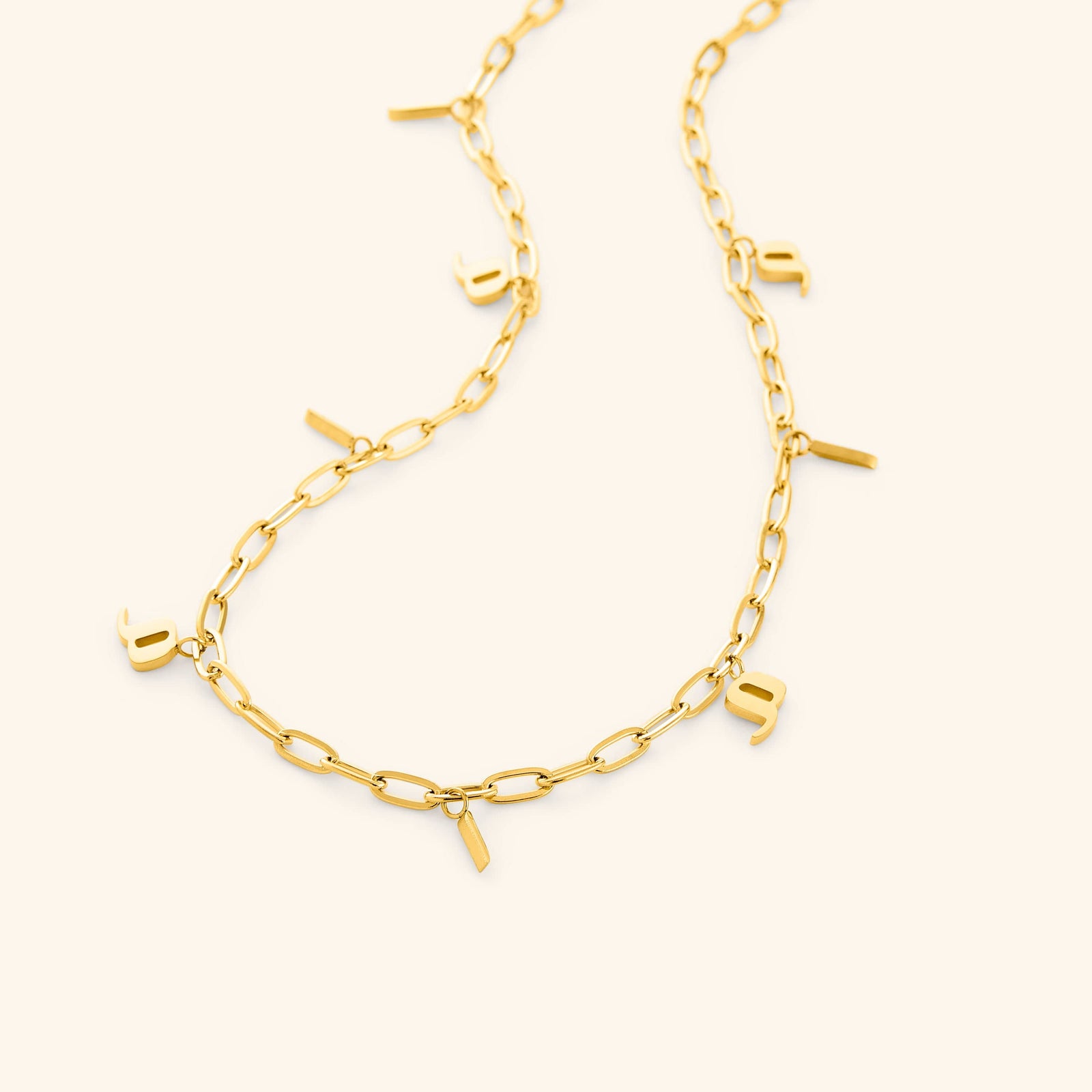 A close-up of the Mama Charm Necklace in 18K gold plating, showcasing the continuous Arabic "Mama" charms linked seamlessly along the chain, reflecting a warm golden hue.