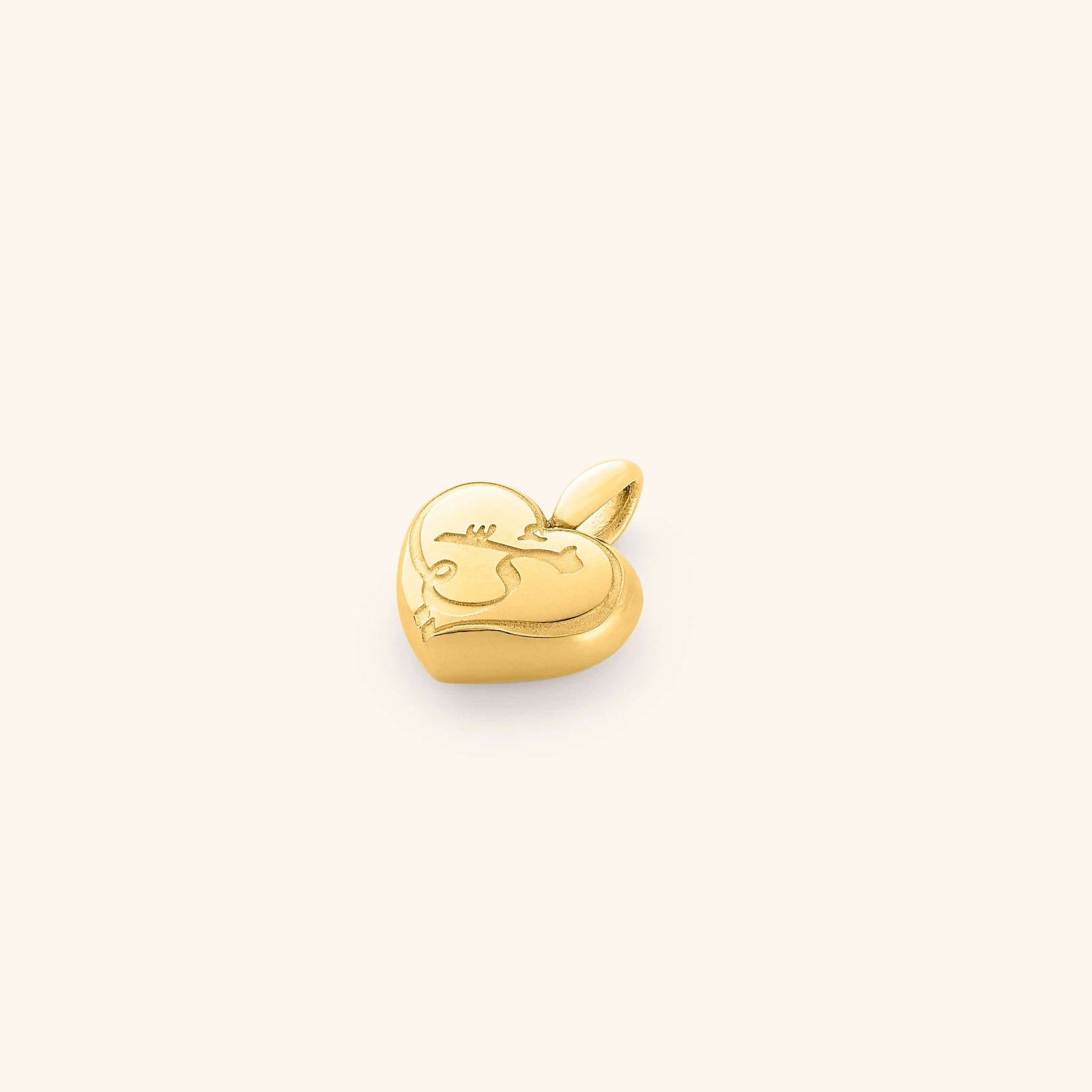 A close-up of the Mama Heart Charm in 18K gold plating, featuring a puffed heart-shaped pendant engraved with the word "mama" in elegant script. The charm is designed to be attached to a chain, showcasing its warm golden hue and polished finish.