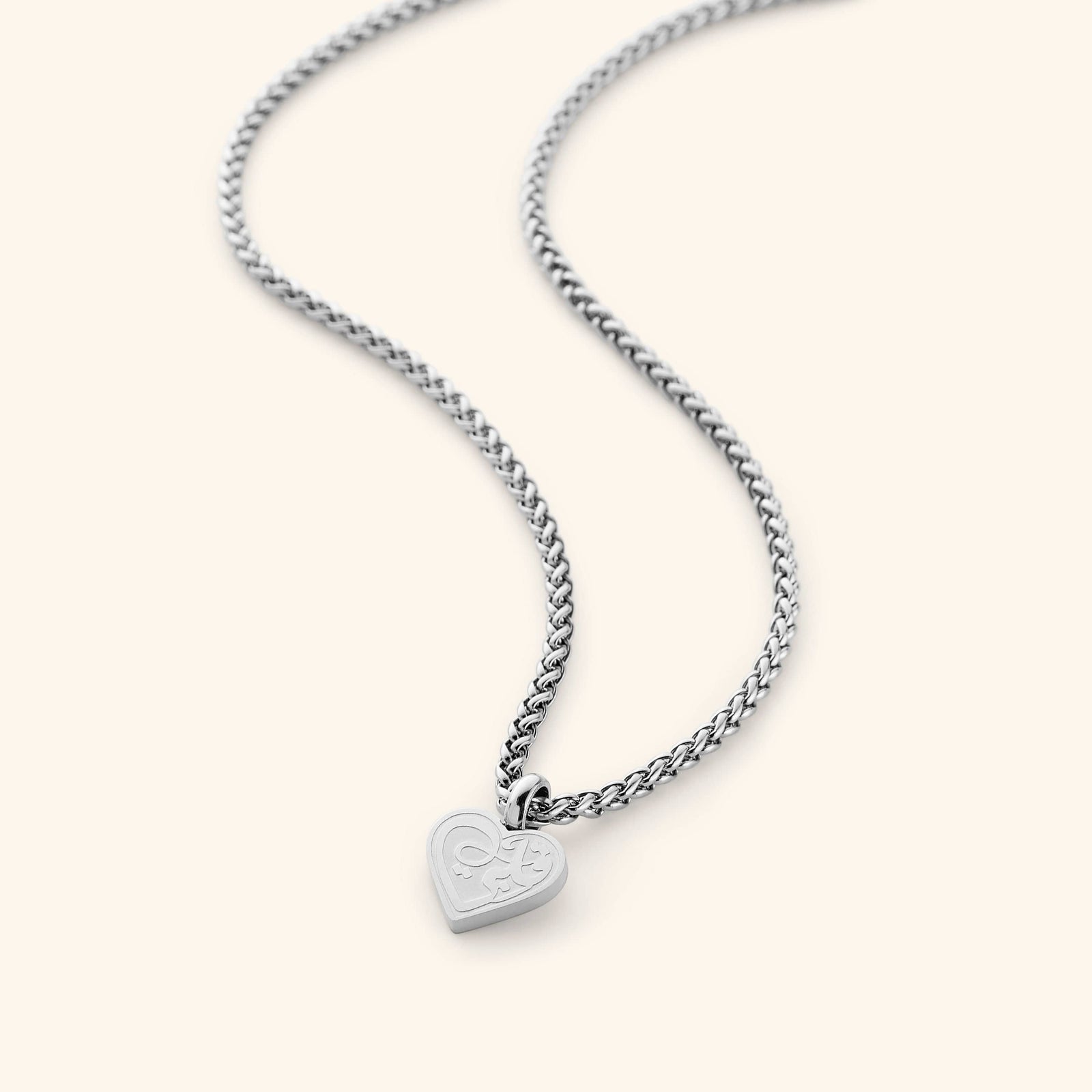 The "Piece of Me" Daughter Necklace in a polished silver finish, showcasing a heart-shaped charm with the Arabic inscription "qalbi," suspended from a sleek wheat chain.