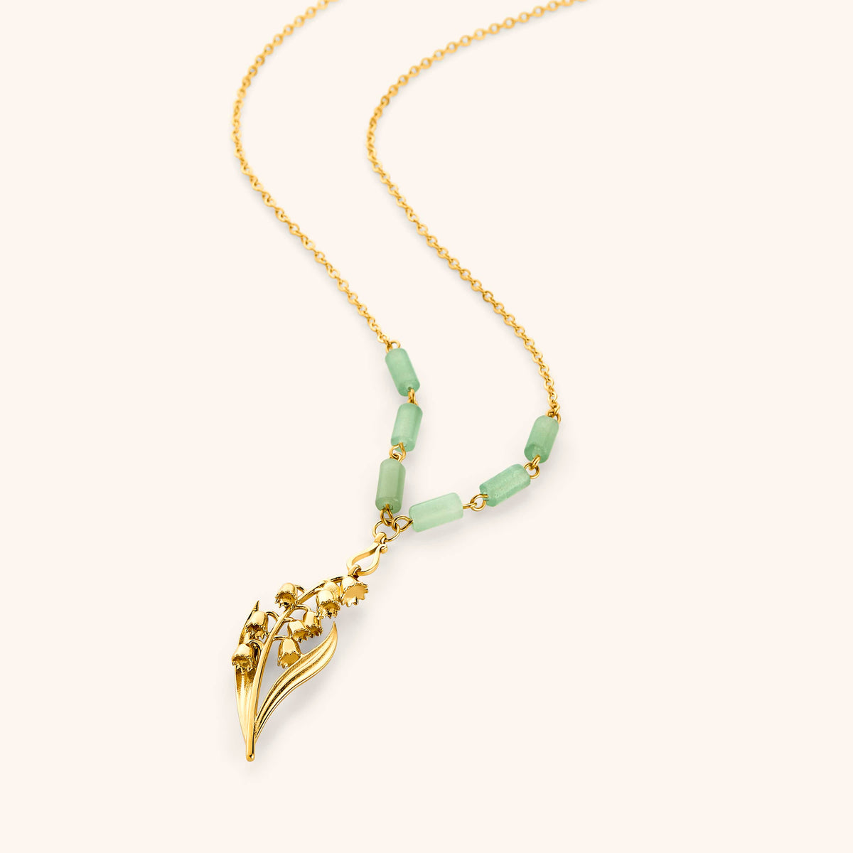 18k gold plated chain necklace with a detailed lily of the valley pendant and pale green tube beads.