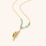 18k gold plated chain necklace with a detailed lily of the valley pendant and pale green tube beads.