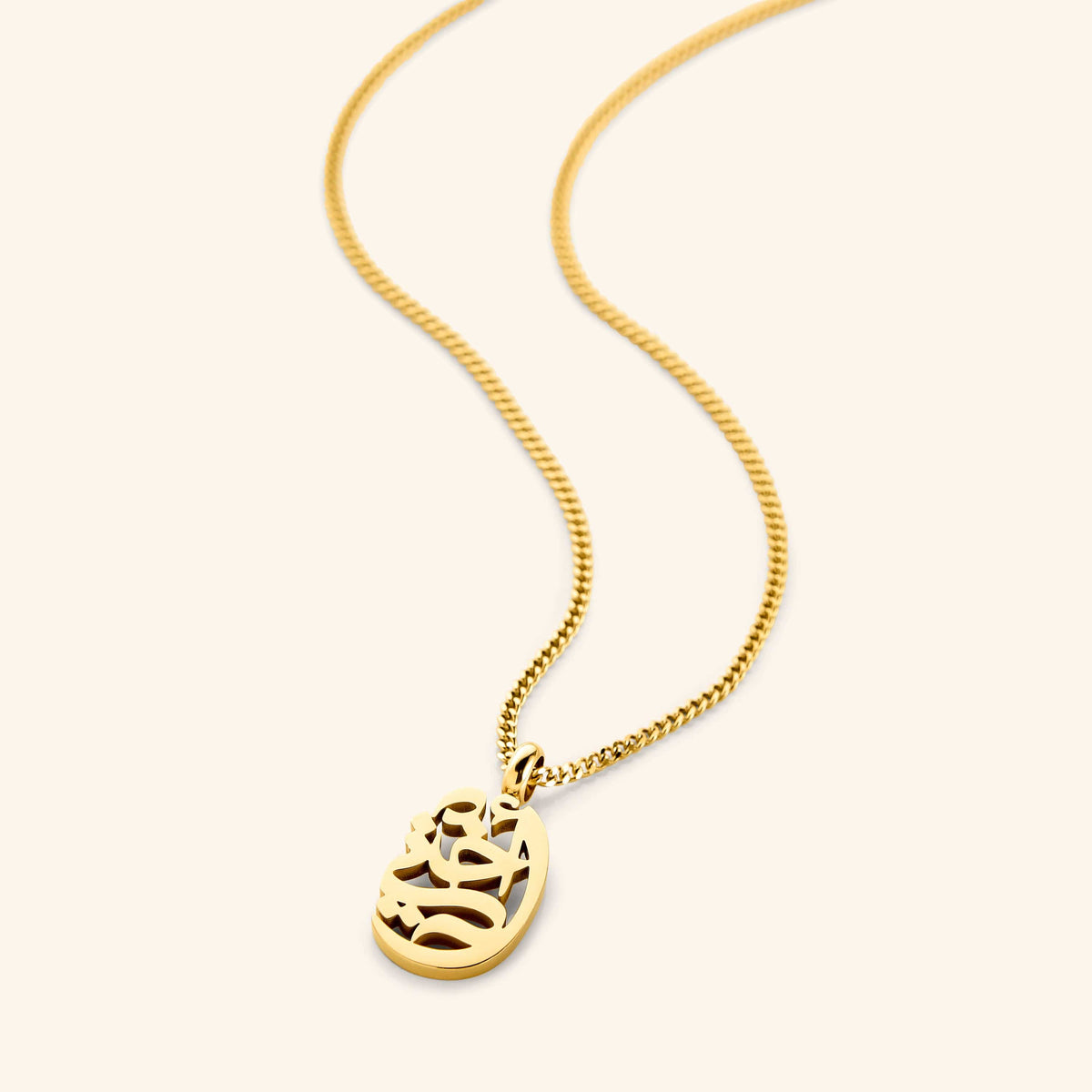 A close-up of the My Sister Oval Necklace in 18K gold plating. The oval pendant features the Arabic word "أختي" ("Ukhti" – My Sister) engraved in elegant calligraphy, suspended from a delicate gold curb chain.