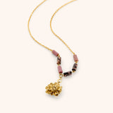 18k gold plated chain necklace with a textured gold flower pendant and pink and black marbled tube beads.