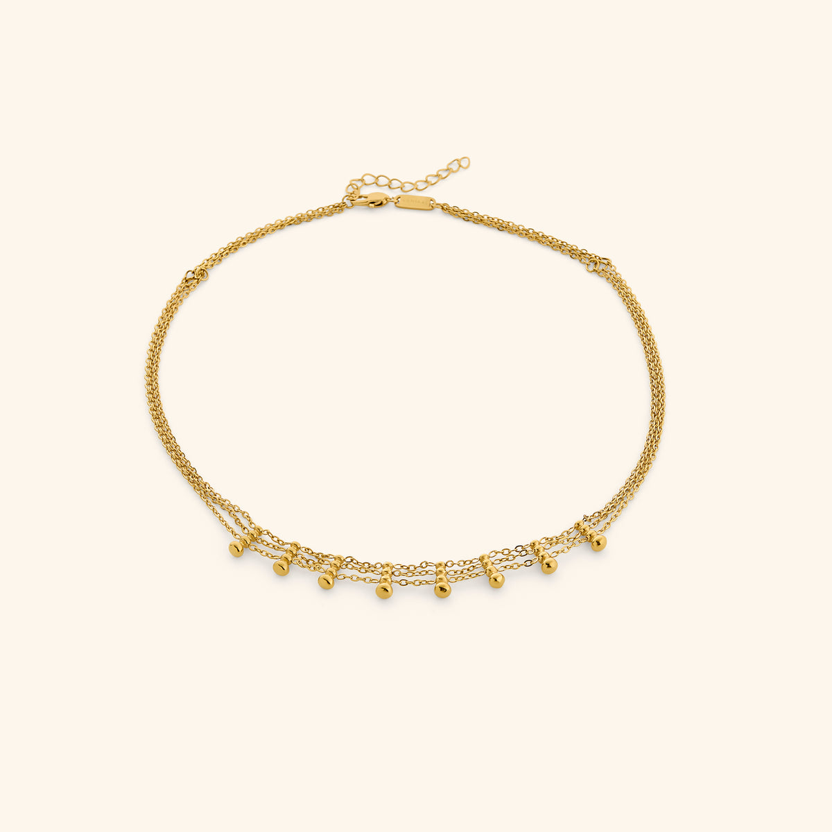 18k gold-plated Raining Heirloom Choker with layered multi-strand chains accented with suspended bead droplets, displayed on an off-white background.