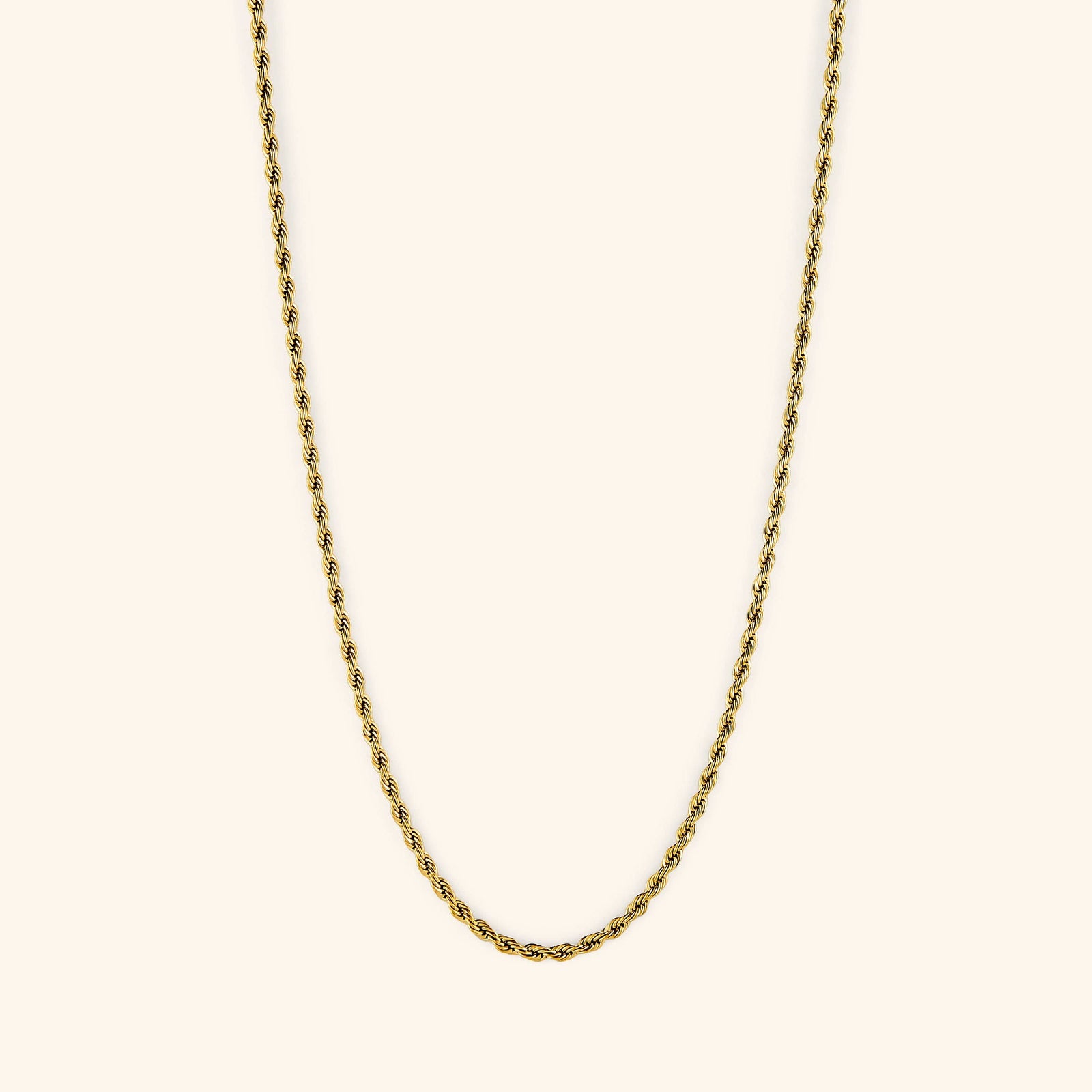 Gold rope chain necklace displayed on a light cream background