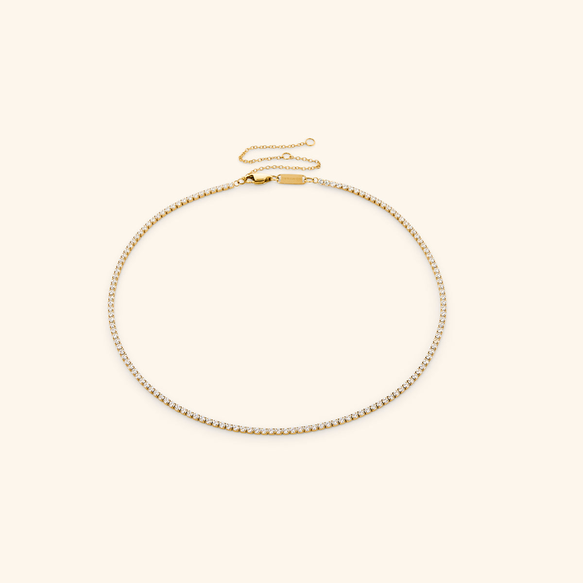 18k gold-plated Tennis Necklace featuring a continuous strand of round clear crystals with an adjustable extension chain.