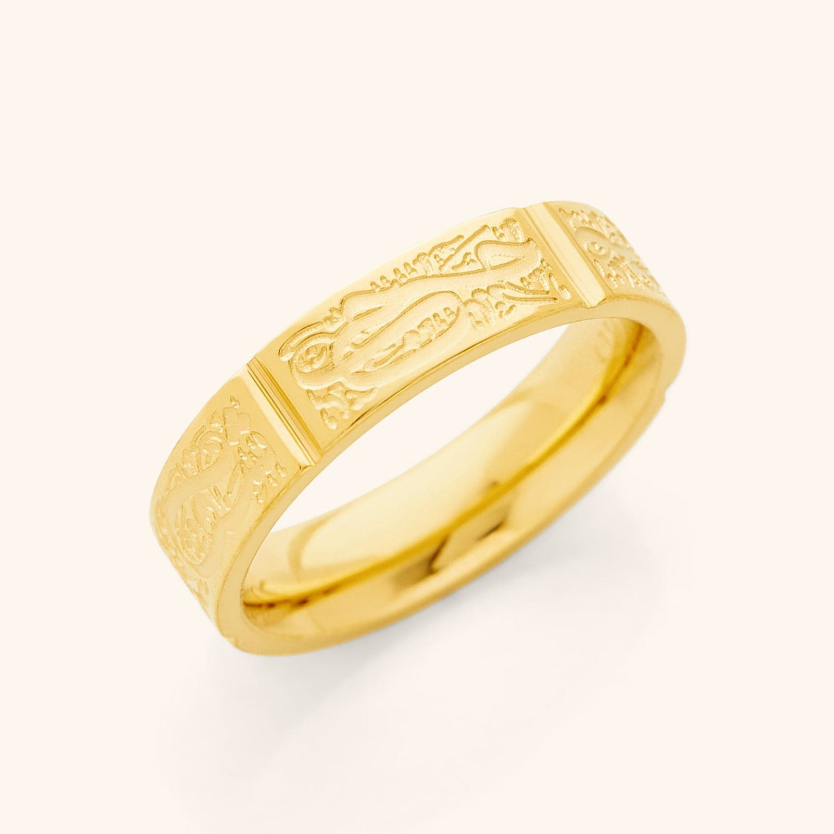 Close-up of a gold ring with engraved Arabic calligraphy sections around the band, representing the Five Pillars of Islam.