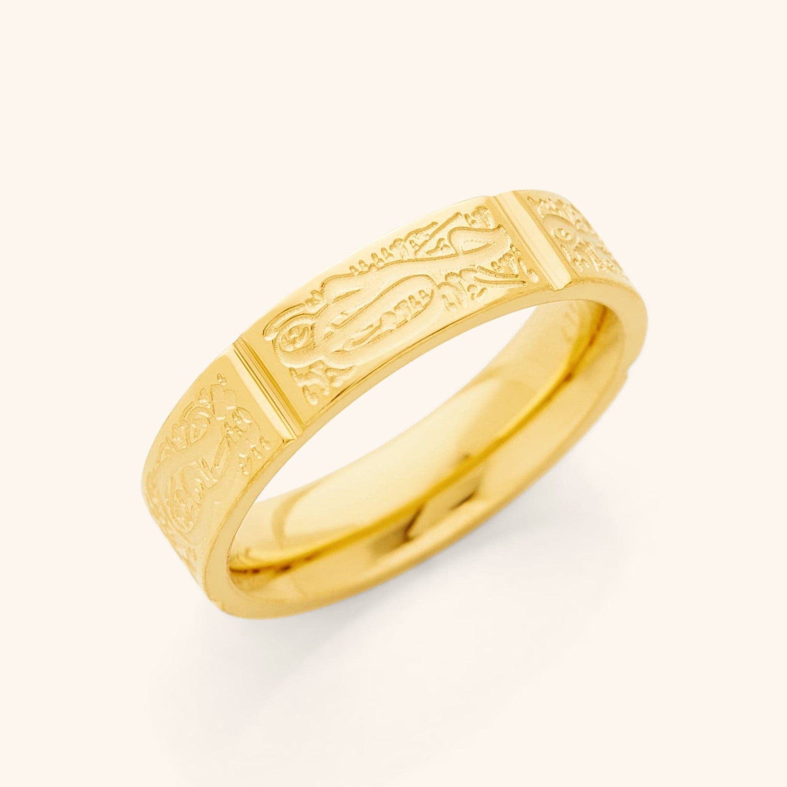 Close-up of a gold ring with engraved Arabic calligraphy sections around the band, representing the Five Pillars of Islam.