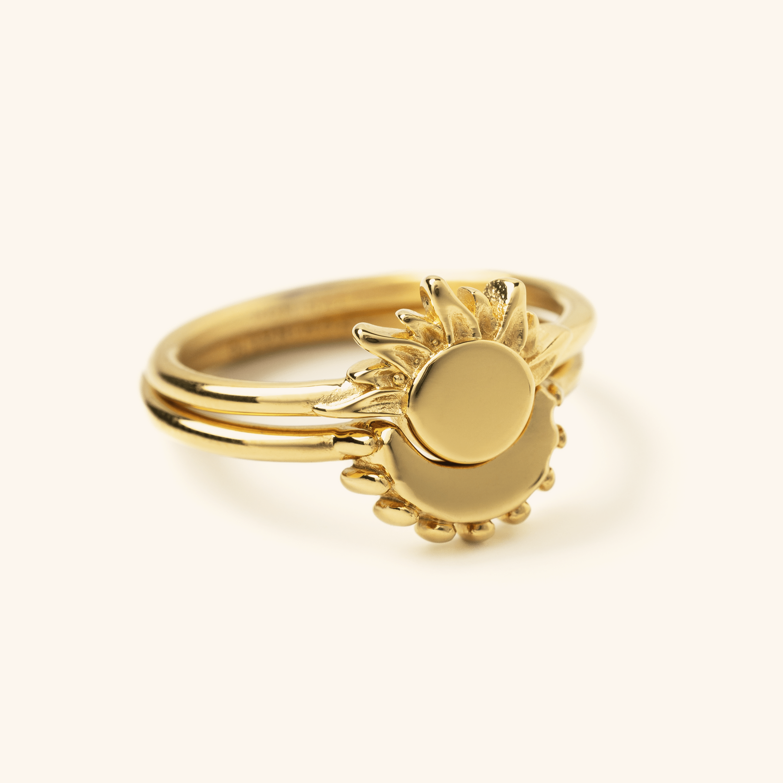 Gold crescent ring stacked with a matching sun ring