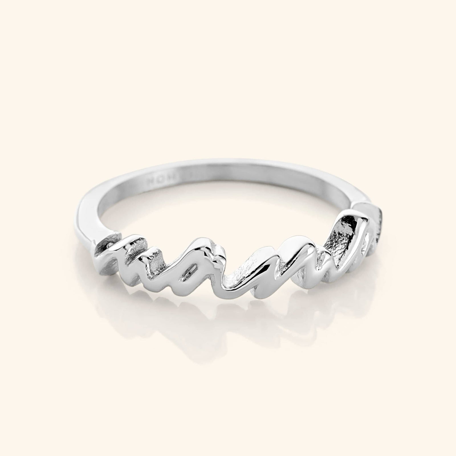A close-up of the English Mama Ring in silver. The ring features the word "Mama" in cursive script.