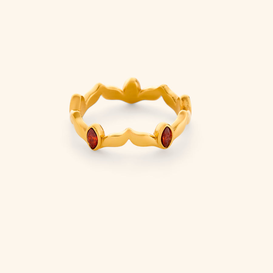 The Garnet Stone Weaving Keffiyeh Ring by Nominal, featuring a contoured 18k gold-plated band sculpted with a traditional keffiyeh weave pattern and accented with rich red garnet stones, displayed on an off-white background.
