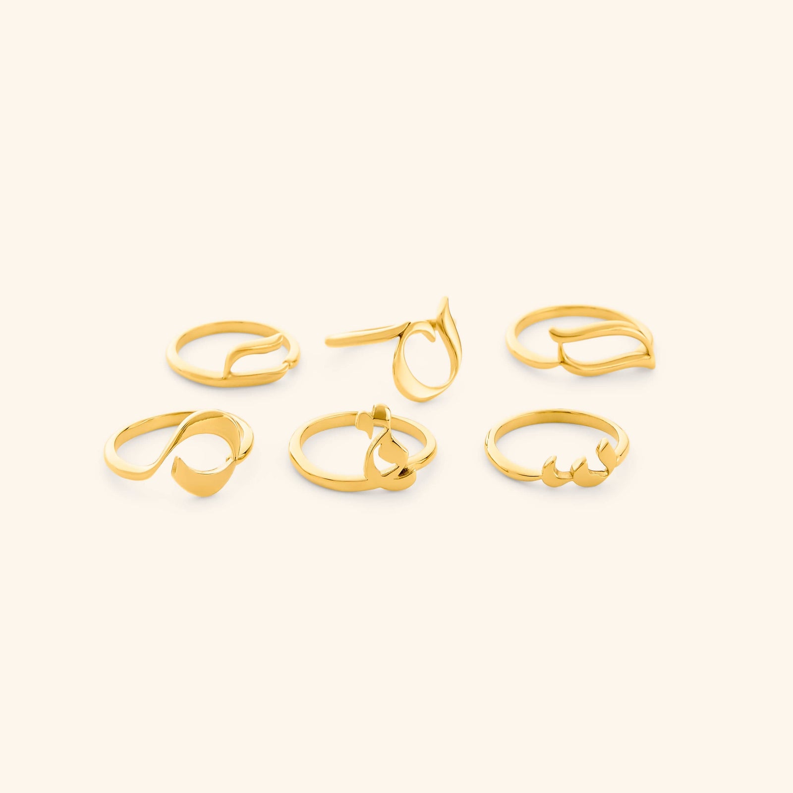 Set of gold Arabic Letter Wrap Rings featuring different letters.