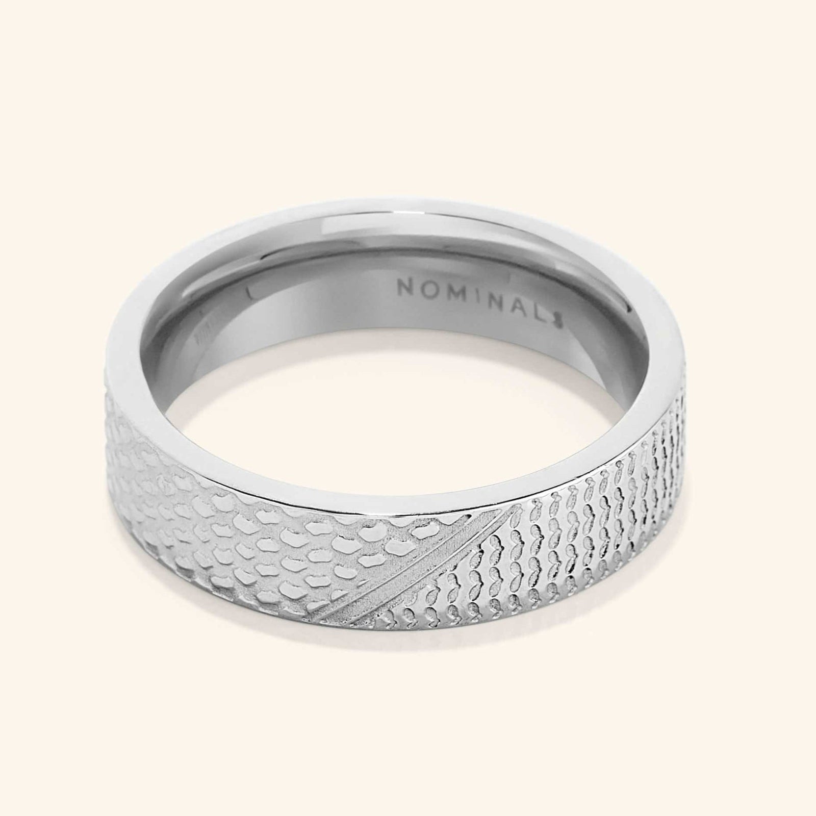 A close-up of the Keffiyeh Ring in silver, featuring intricate engravings inspired by the traditional Palestinian keffiyeh pattern, including fishnet designs, bold lines, and olive leaves.