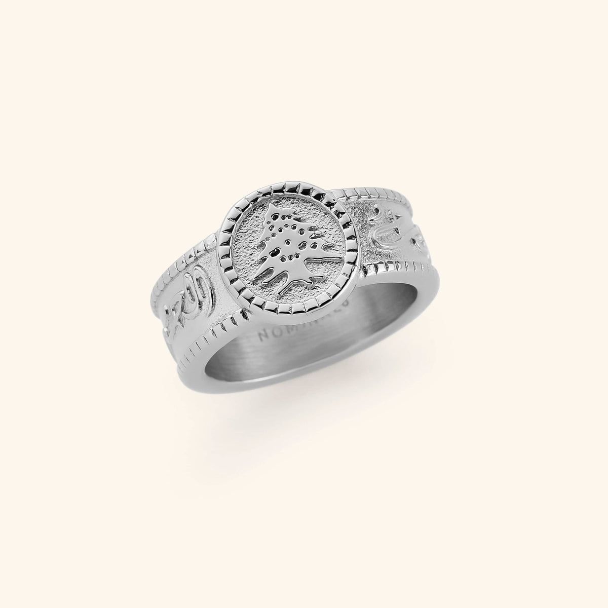 Silver ring with "Freedom is the soul" inscribed in Arabic along the perimeter of its band, leading to a plate that hold the iconic Cedar of Lebanon.