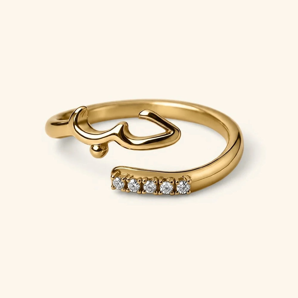 18k gold-plated Love Wrap Bezel Ring featuring an open wrap band with Arabic "Hub" (Love) calligraphy on one end and a line of bezel-set clear crystals on the other.