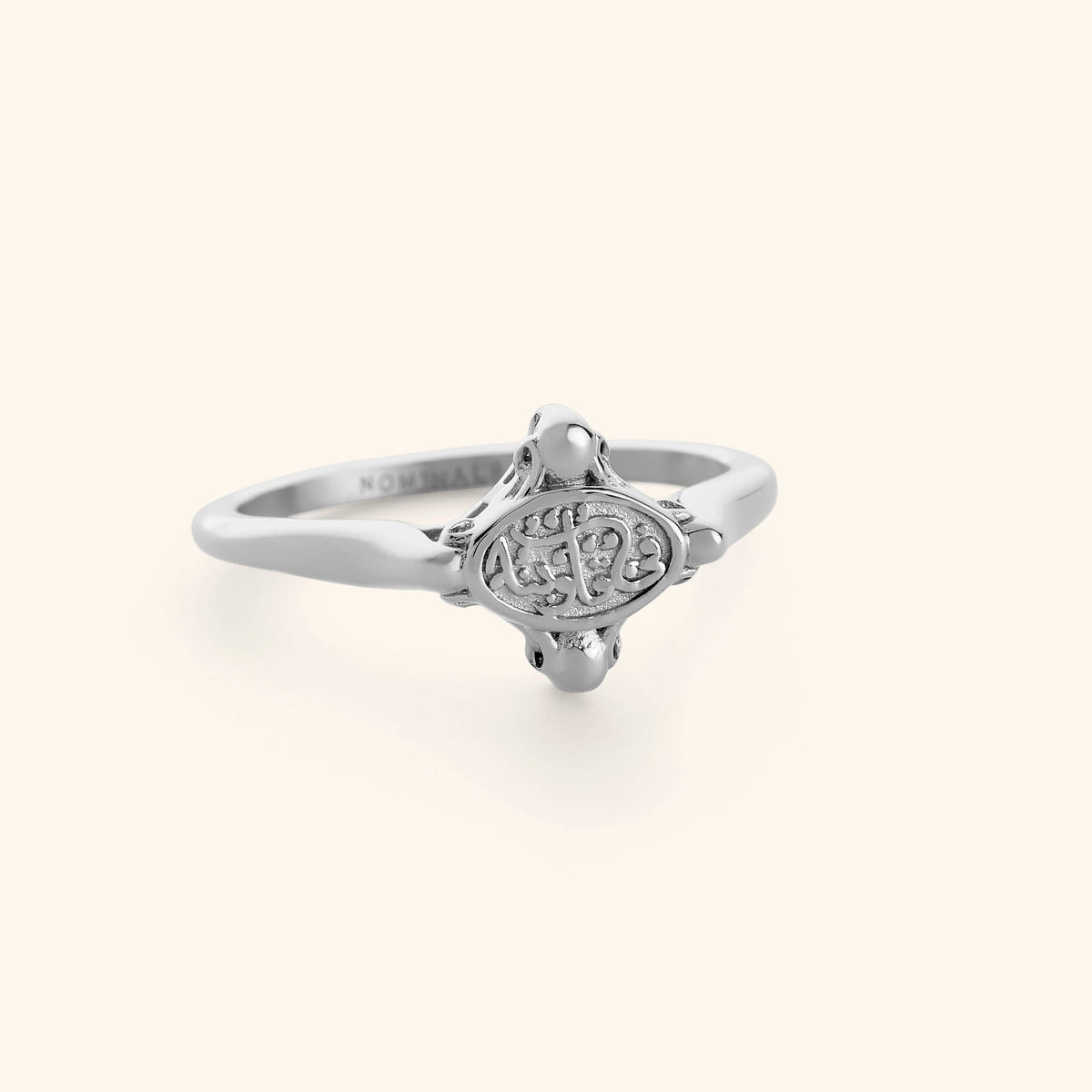 Minimal silver ring with "in our hearts" inscription on its plate.