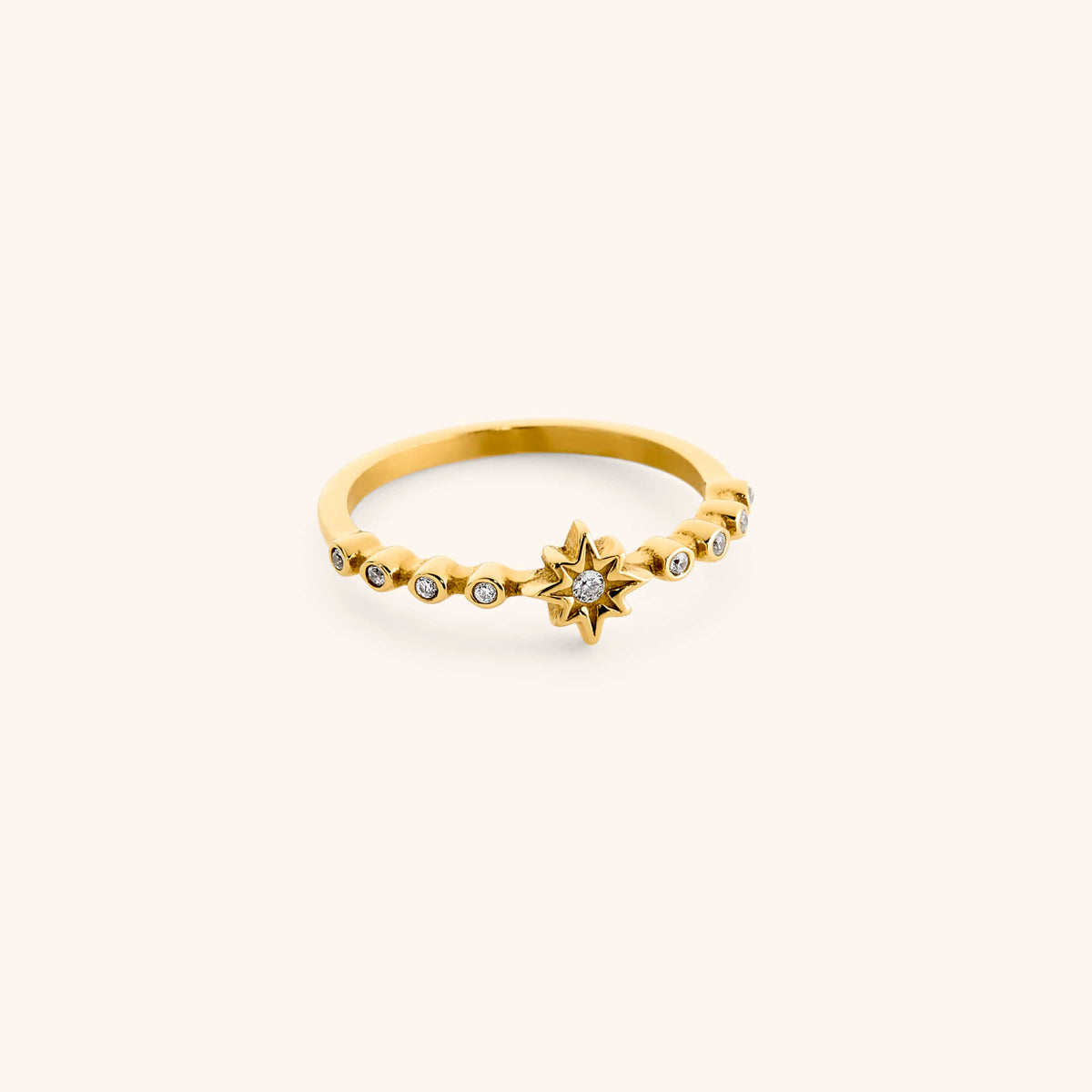 18k gold-plated North Star Bezel Ring featuring an eight-pointed star centerpiece flanked by bezel-set clear crystals.