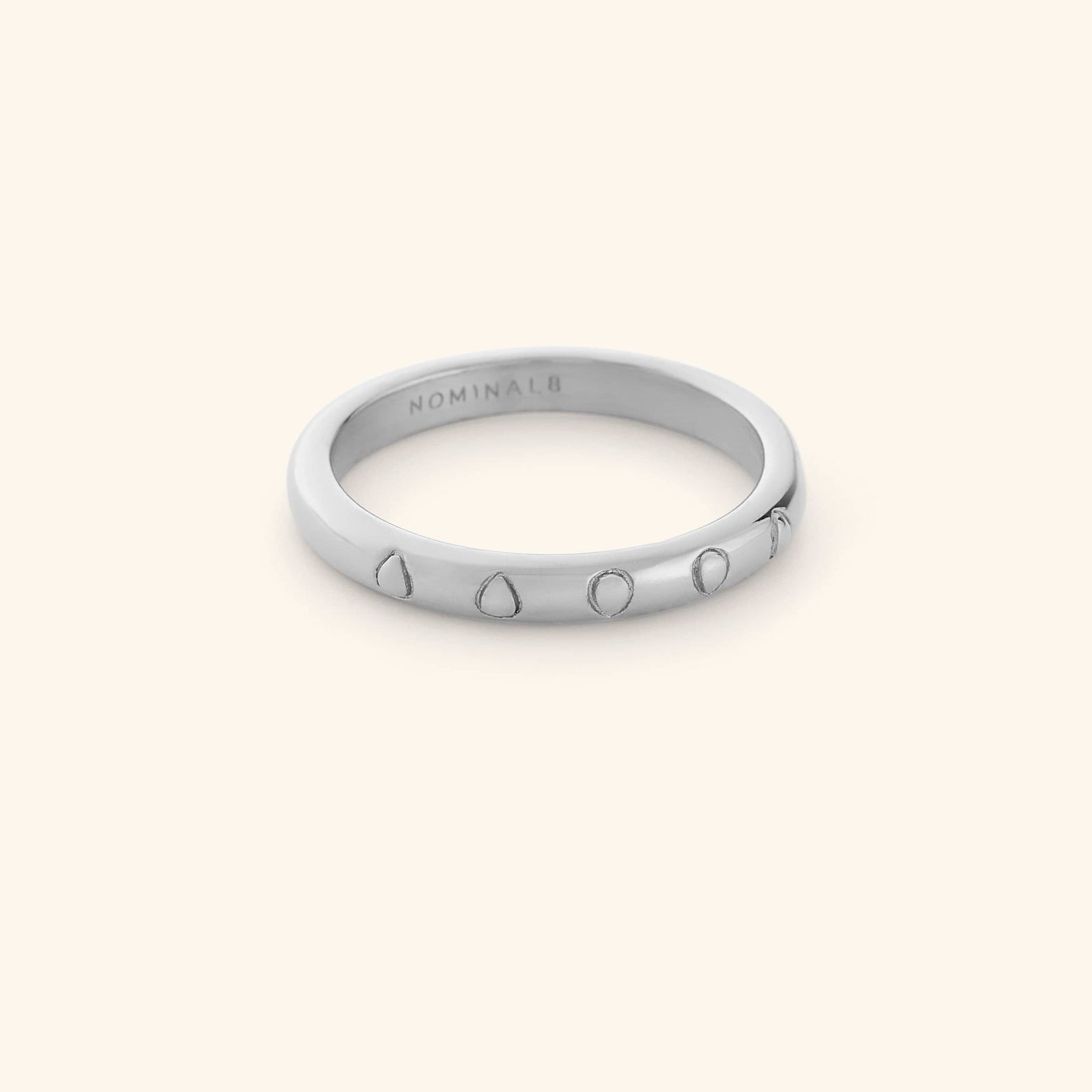 Silver ring featuring carved watermelon seeds along a clean band.