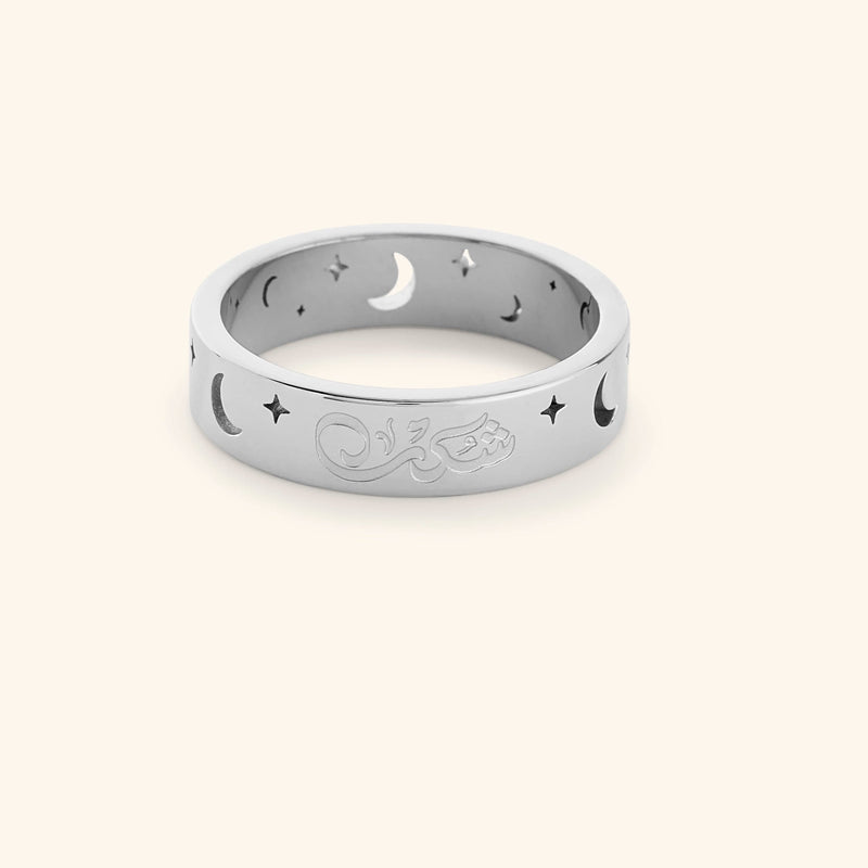 Silver ring with cutout star and moon design and an engraving that reads "Shukr" pimage_ shot on a white background