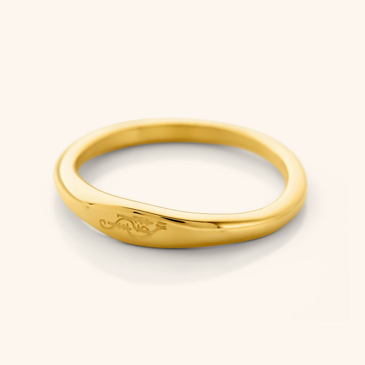 Gold band ring with the engraved Arabic phrase meaning "My Sister"