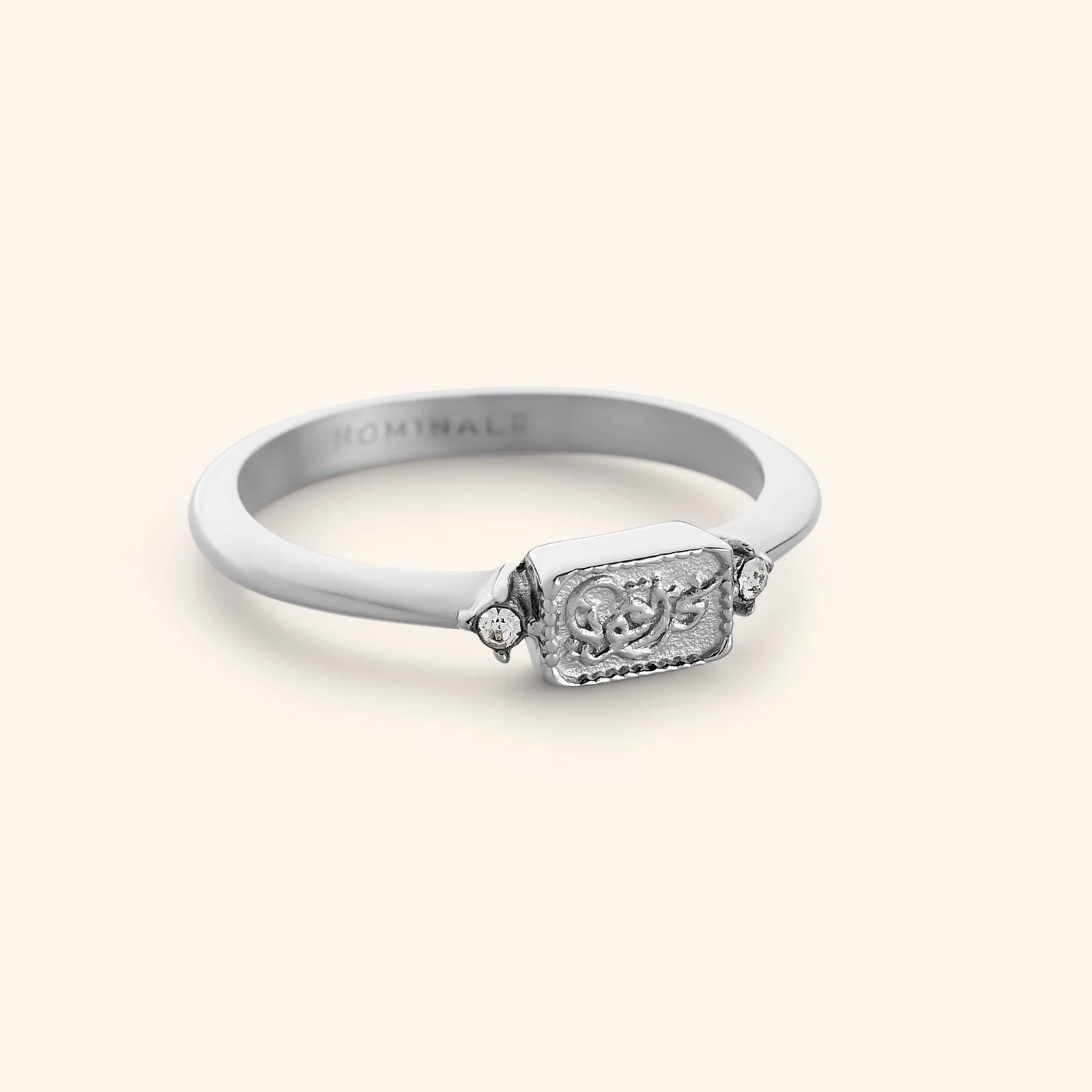 Silver minimal band ring with a rectangular plate design that reads "we are strong" in Arabic calligraphy.