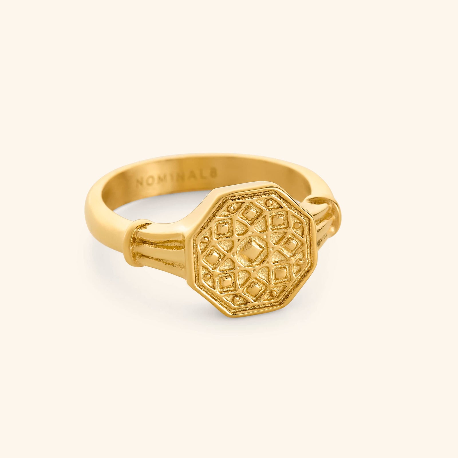 An 18K gold plated ring with a hexagonal plate that features patterns inspired by the Damascus region.