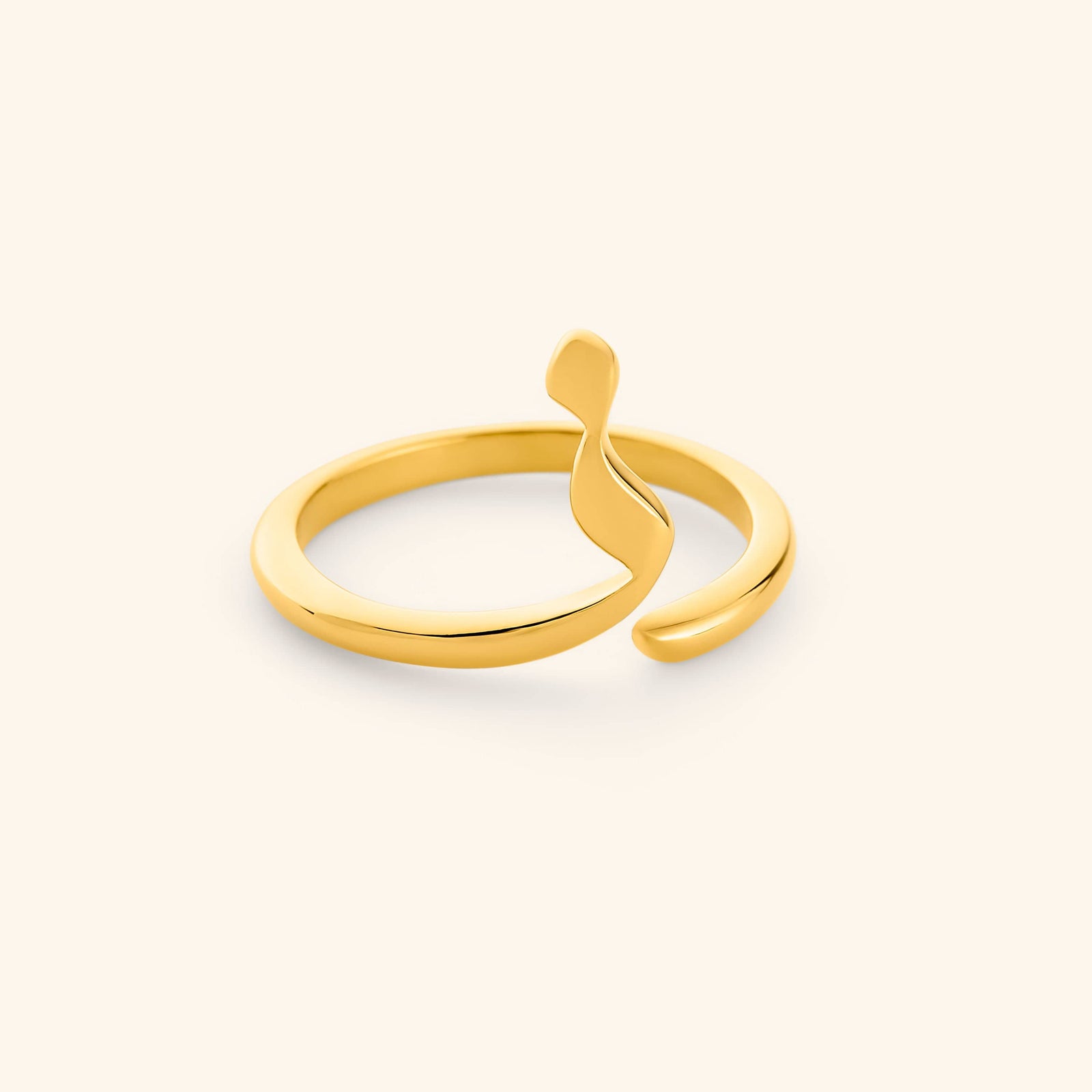 An 18k gold plated ring featuring a single Arabic letter wrapped around a timeless band.