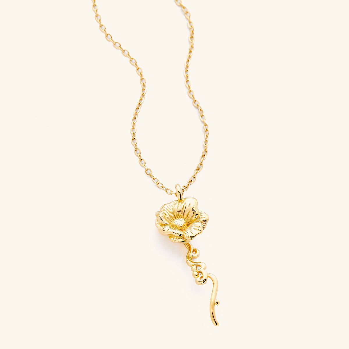 An 18k gold plated necklace with the anemone flower shaped pendant that features  Arabic word for ‘written’, curving in calligraphy out of the stem of the flower.