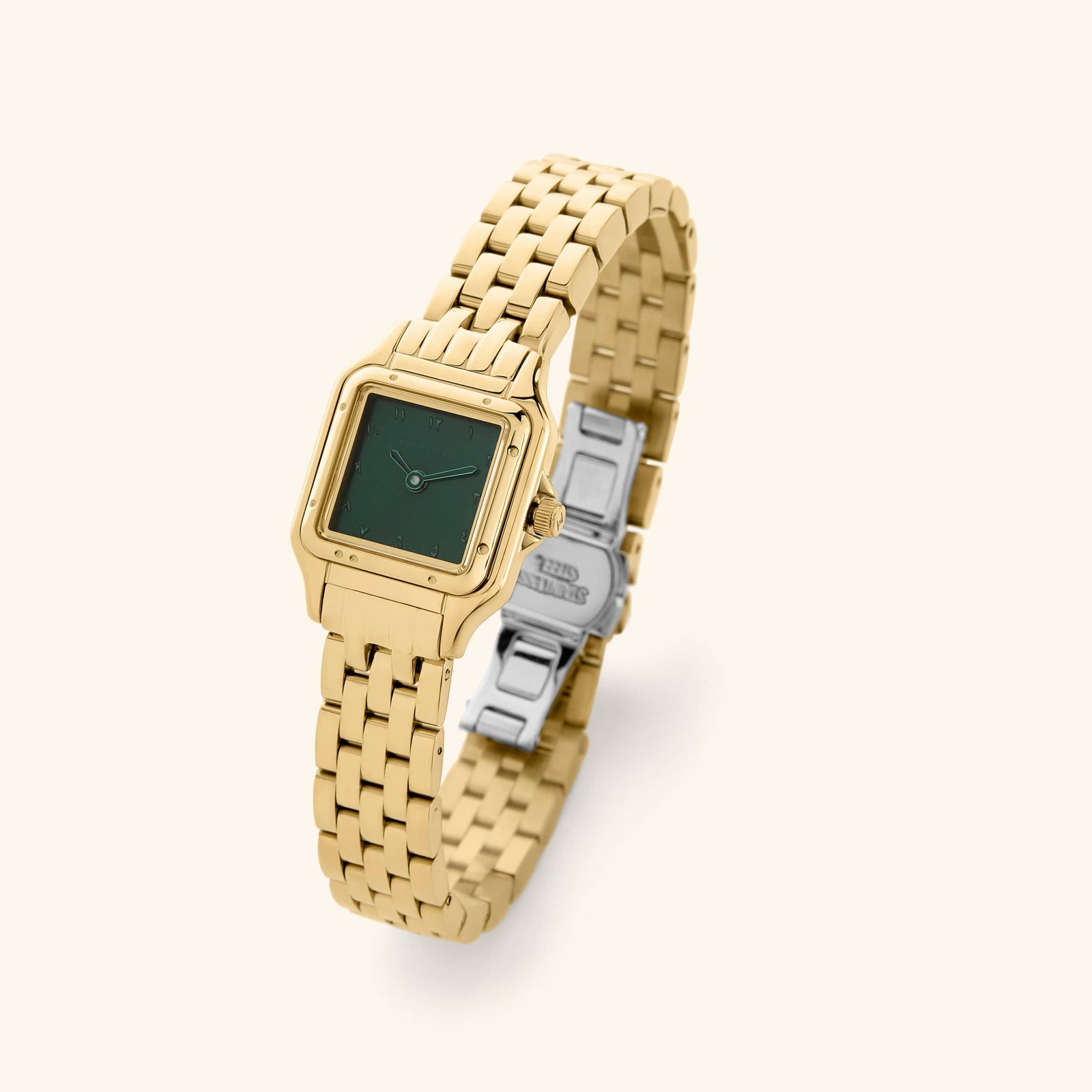 An analog watch that features gold and emerald combination with a rectangular face and a monochromatic face design.